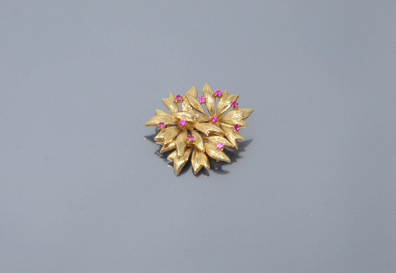 Null 18K(750)金胸针，叶子图案镶嵌着粉色合成宝石。

主挂：查尔斯-加尼埃。

鹰头胸针。

尺寸：约4.5 x 4厘米。- 毛重：5.70克。