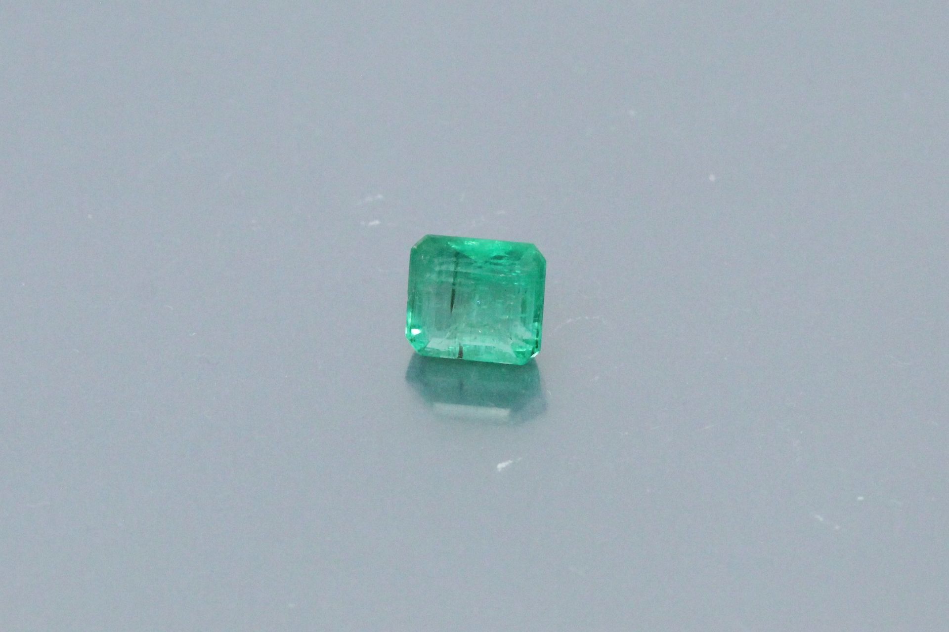 Null Rectangular emerald with cut sides on paper. 

Accompanied by an AIG certif&hellip;
