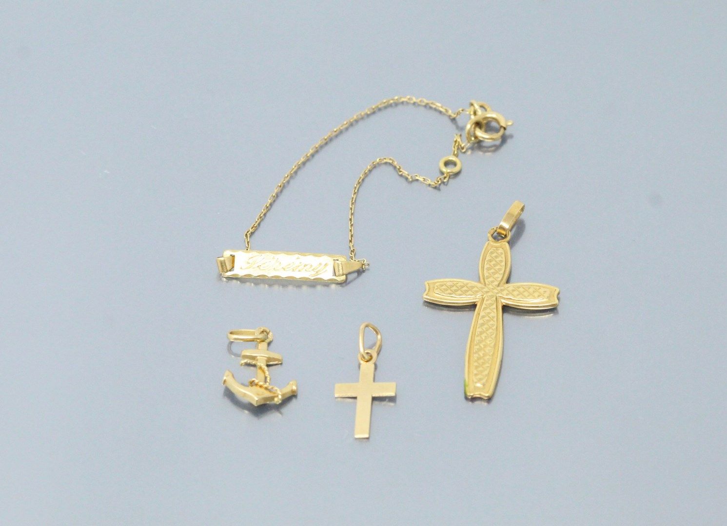 Null 18k (750) yellow gold lot comprising three pendants and a bracelet. 

Weigh&hellip;