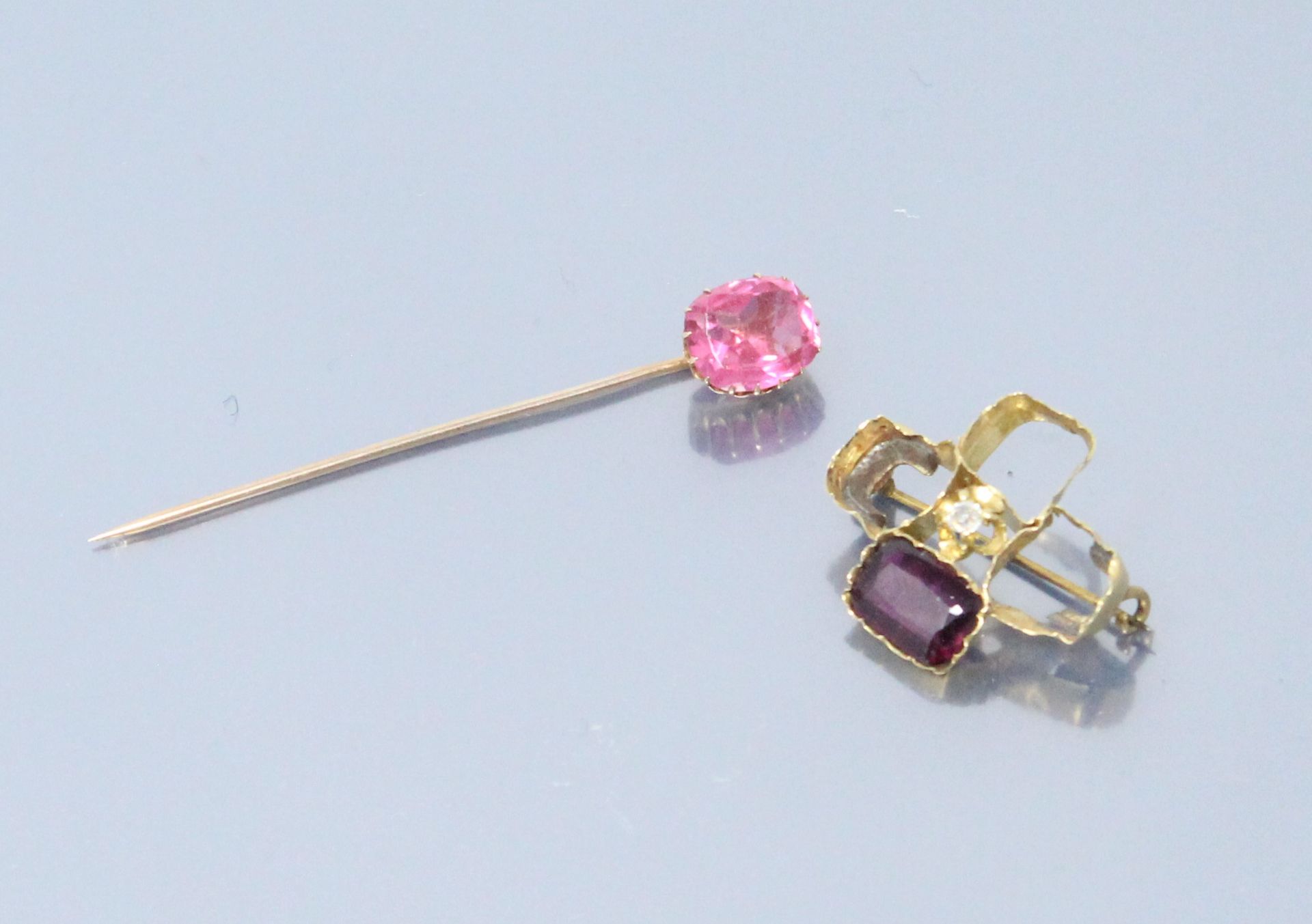 Null 18K(750)黄金胸针，镶嵌着一颗粉色宝石。

一枚18K(750)黄金胸针，上面镶嵌着一颗紫罗兰石和一颗小钻石（其他三颗宝石不见了）。

毛重：7&hellip;