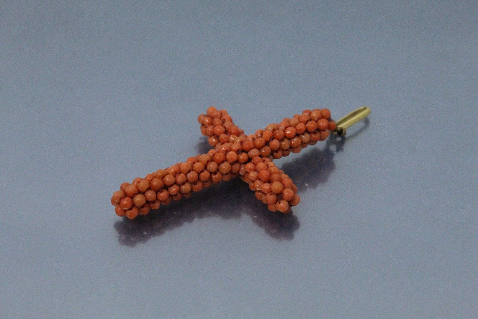 Null Kreuzförmiger Perlenanhänger aus kleinen Korallenperlen. Die Schließe ist a&hellip;