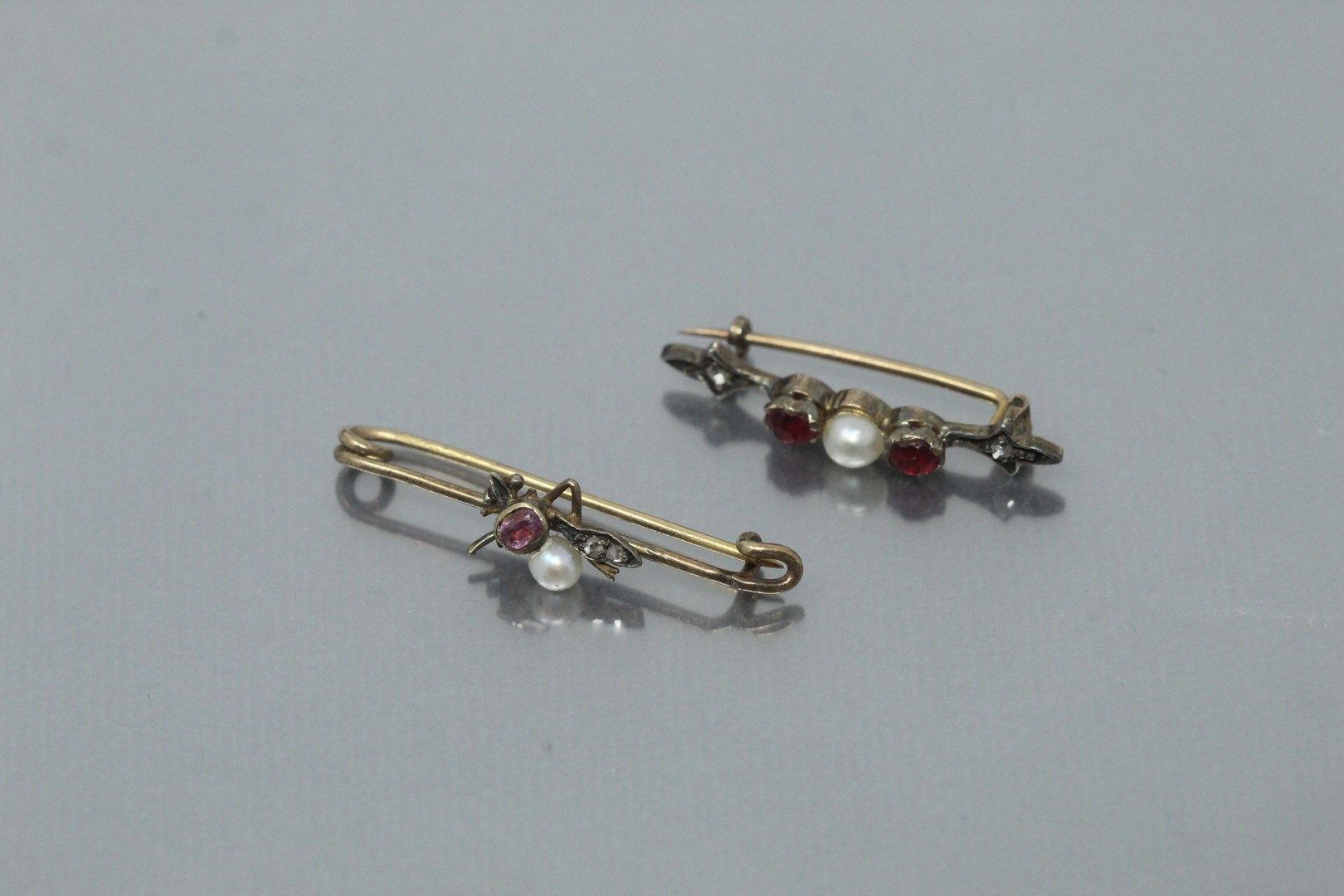 Null 拍品包括一枚18K(750)黄金和银质胸针，上面有两颗红宝石和一颗珍珠，以及一枚18K(750)黄金和银质胸针（acc.

毛重：3.24克。
