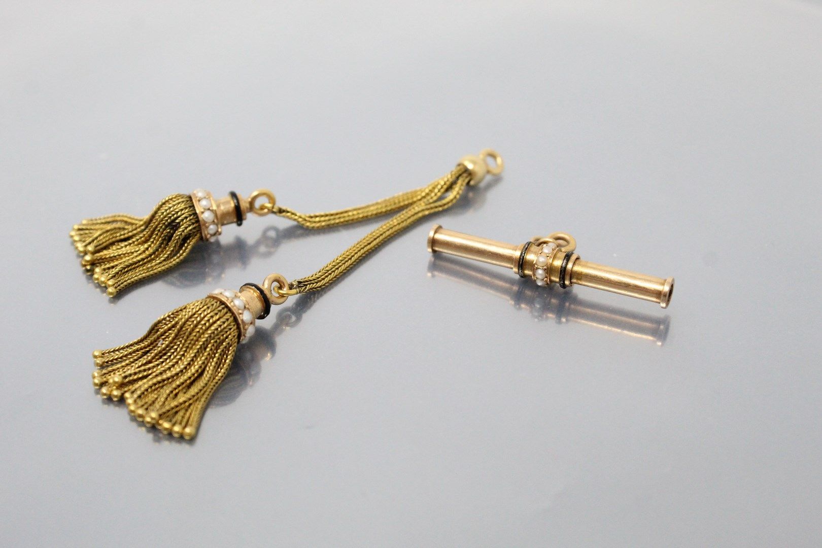 Null 18K（750）黄金和珍珠吊饰。

附有一只18K（750）黄金和珍珠的小型机械铅笔。

毛重：14.91克。