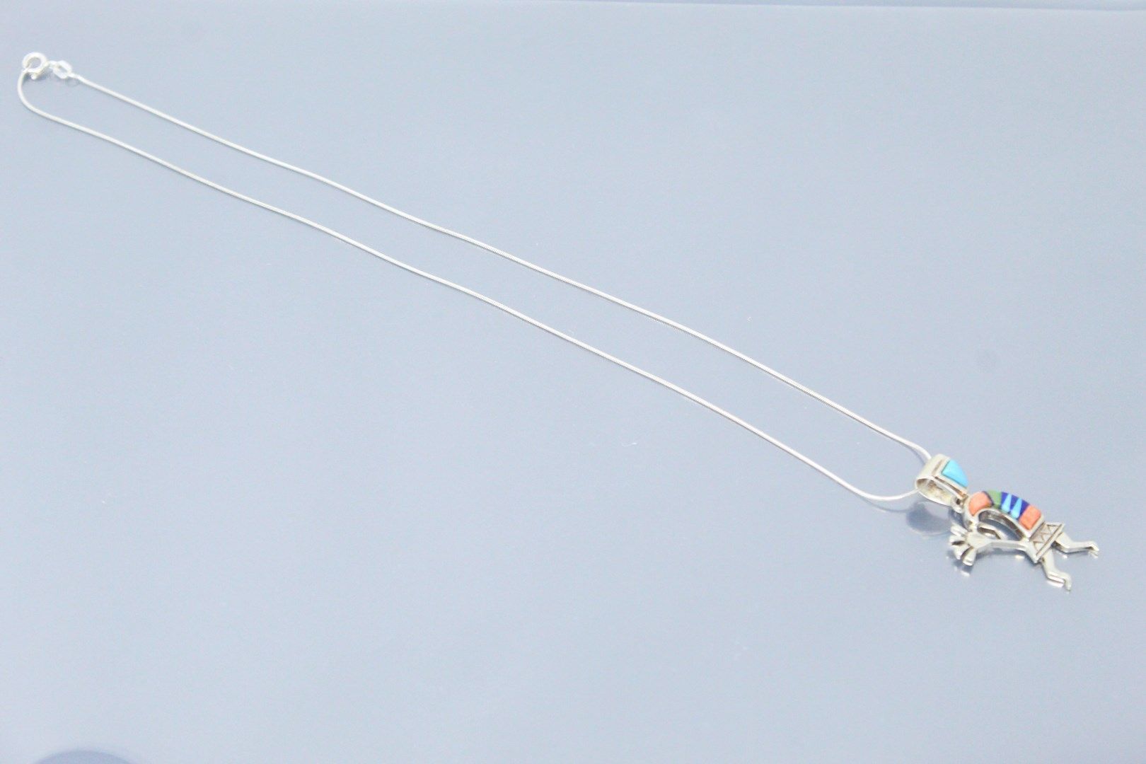 Null 银色蛇形链和一个彩色吊坠，上面有银色的签名 "Calvin Begay"。

颈部长度：45厘米。- 毛重：6.58克。