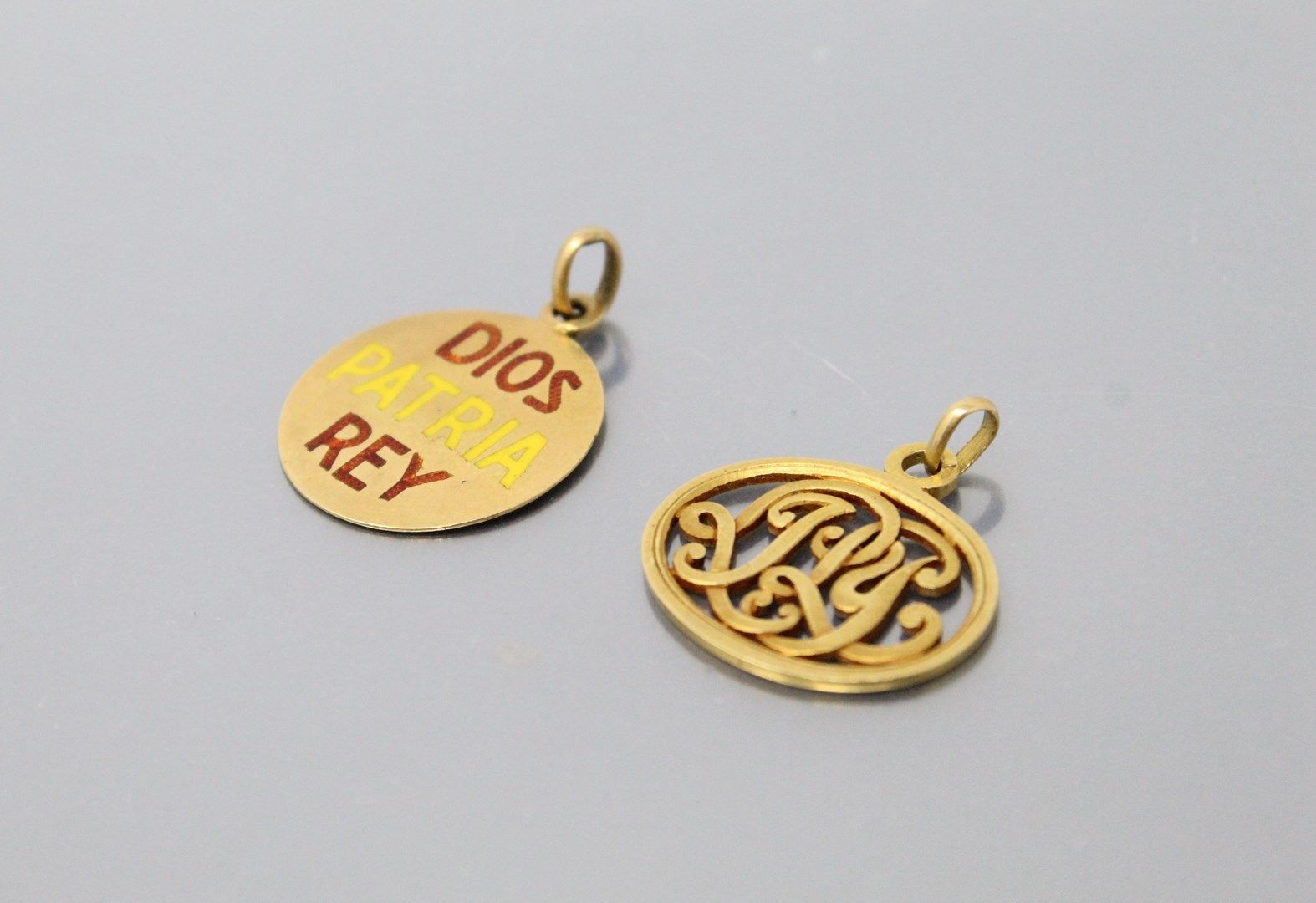 Null 两枚18K(750)黄金奖牌，一枚背面有珐琅铭文Dios, Patria, Rey和西班牙国旗；另一枚在椭圆形镂空框架内有交错的字母。

毛重：7.9&hellip;