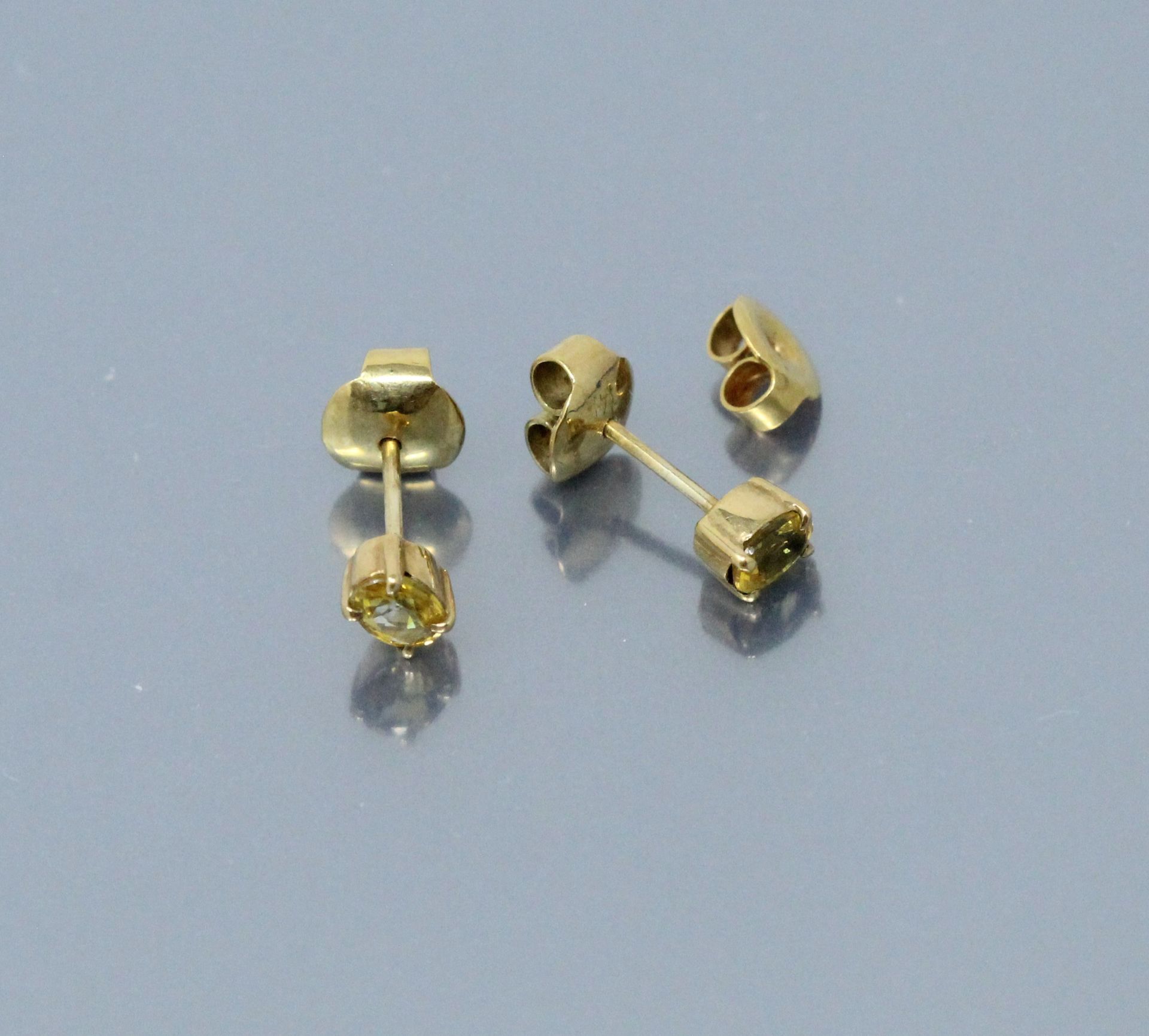 Null 一对8K(750)黄金耳钉，每个耳钉都有一颗椭圆形的黄色蓝宝石。附有一个18K（750）黄金夹。

毛重：1.66克。