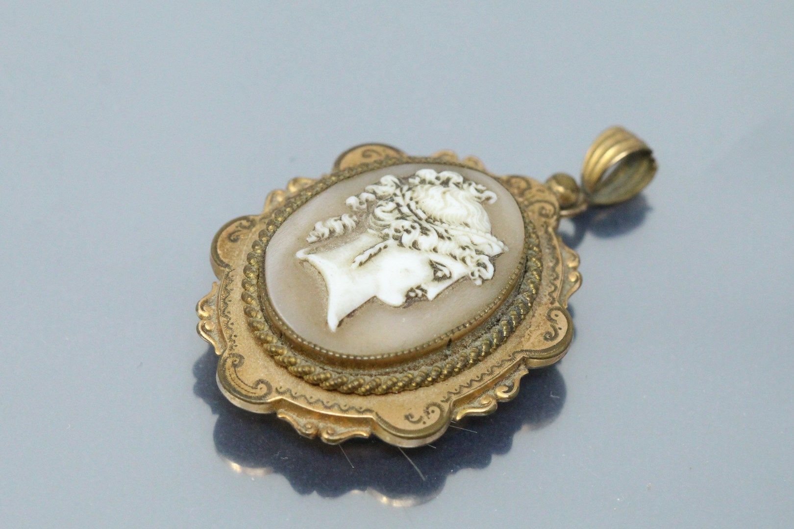 Null Metal pendant with a cameo of a lady's profile.