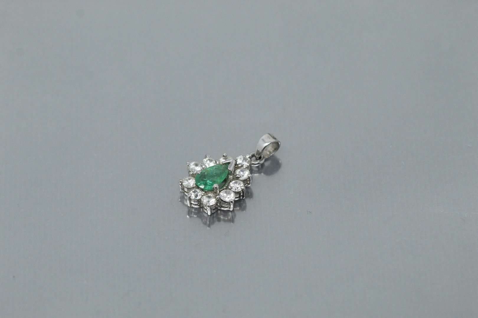 Null 9k(375)白金吊坠，镶嵌着一颗绿宝石，周围是白色的石头。

毛重：2.12克。