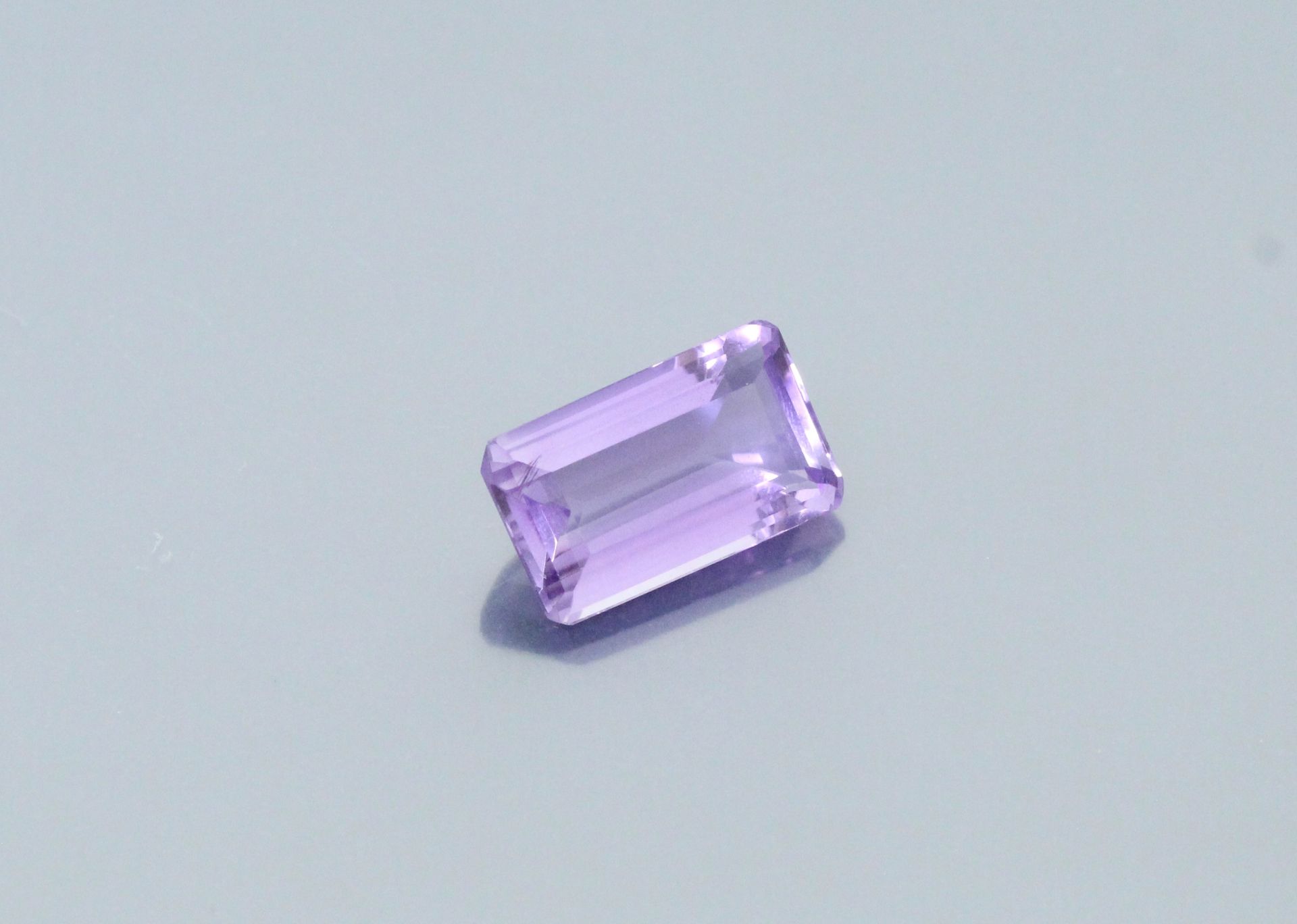 Null 长方形的紫水晶，纸上有切面。

重量：19.22克拉。