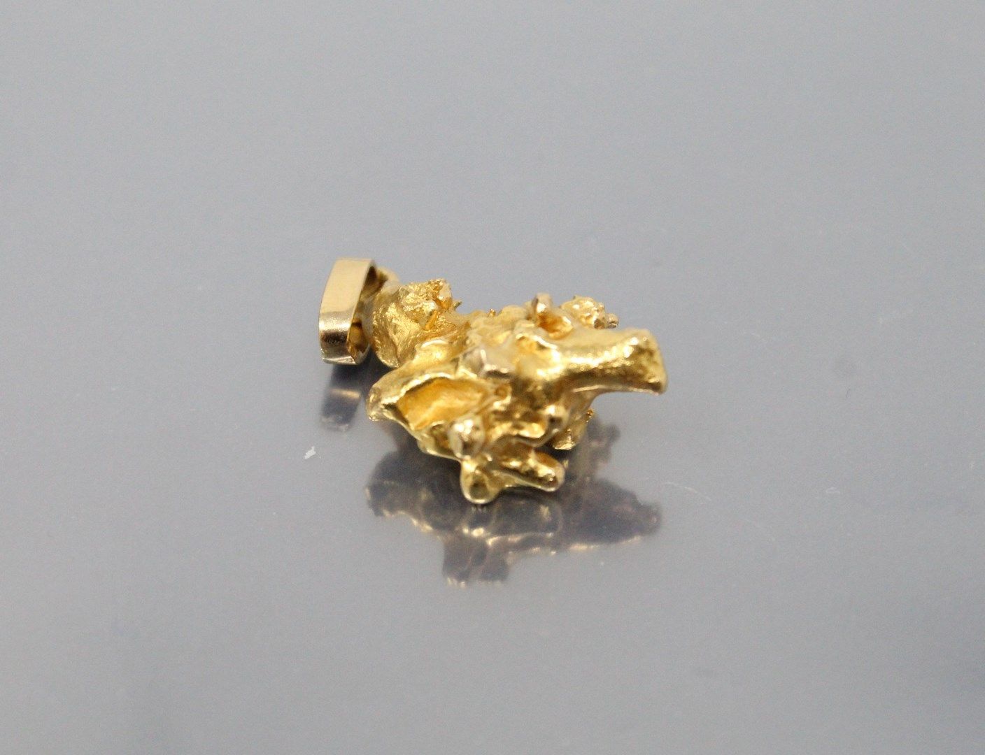 Null 18K（750）黄金吊坠造型的金块。

重量：11.61克。