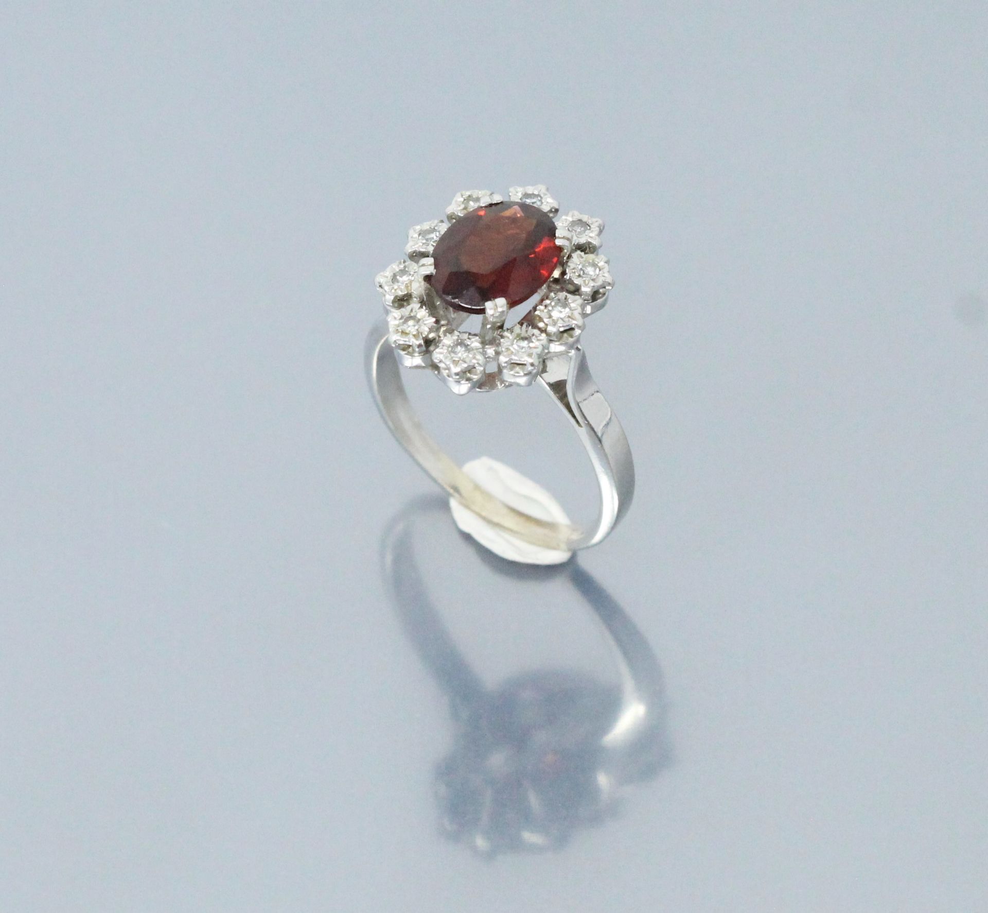 Null 18k (750) white gold ring set with an oval garnet in a diamond setting. 

H&hellip;