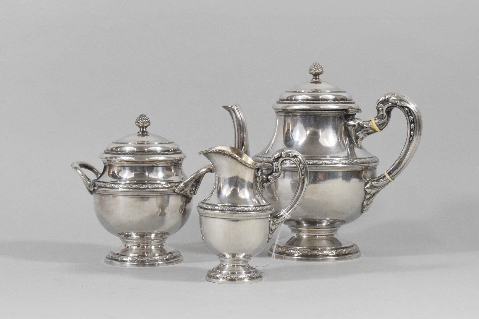 Null 银质茶具（Minerva），月桂树楣装饰，刺桐叶把手，盖子上有一串珍珠，松果把手。它由一个茶壶、一个牛奶壶和一个糖碗组成。20世纪。

重量：1014&hellip;