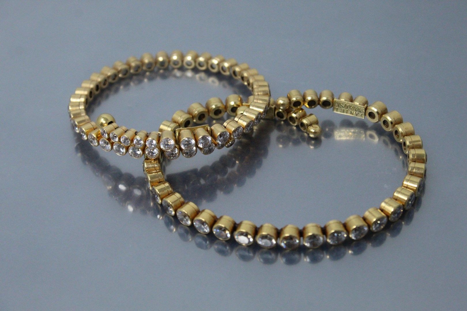 Null Two 18k (750) yellow gold and steel bracelets with white crystals.

Signed &hellip;