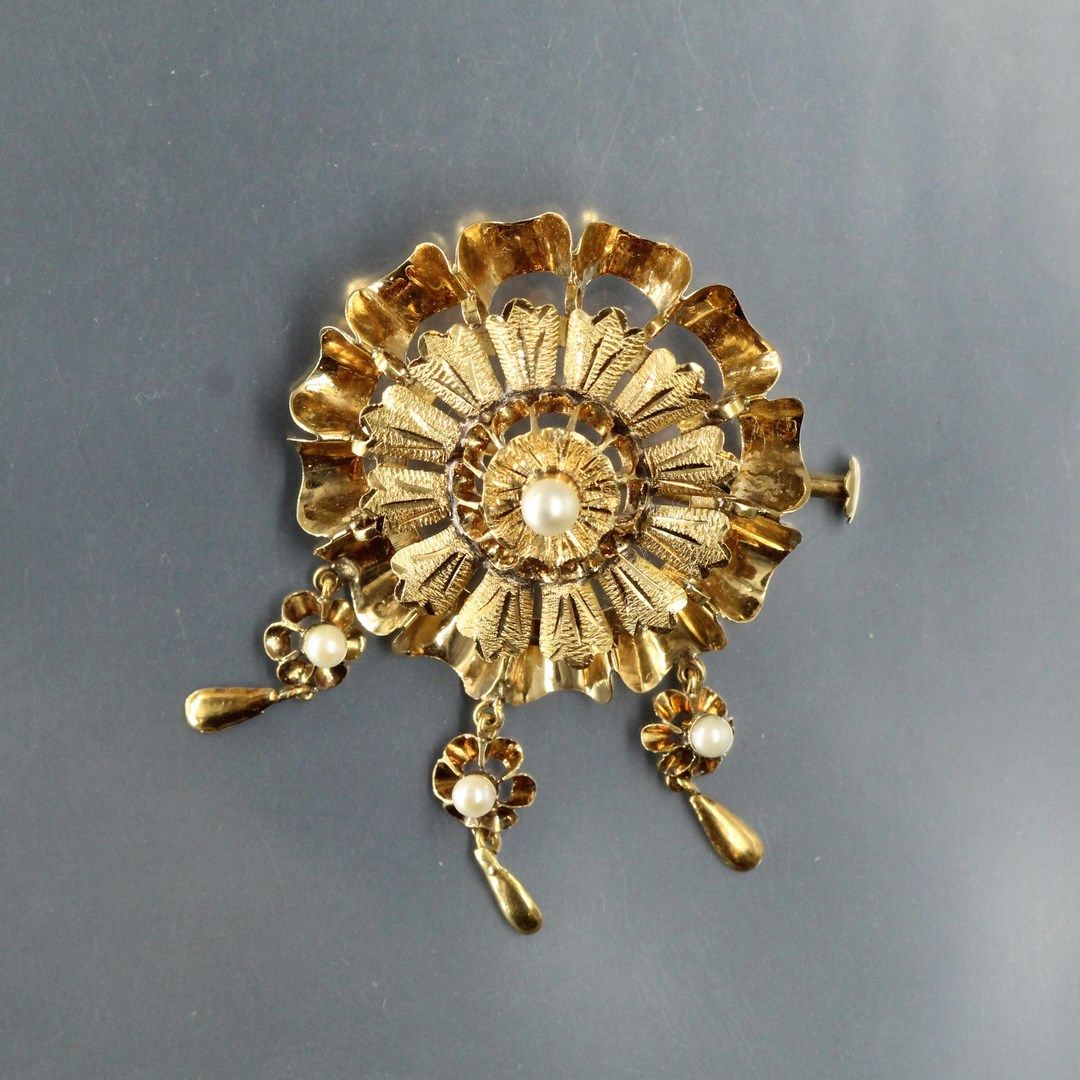 Null 18K（750）黄金胸针，形状为一朵花，中间有一颗珍珠，吊坠末端有三颗小的珍珠。

毛重：5克