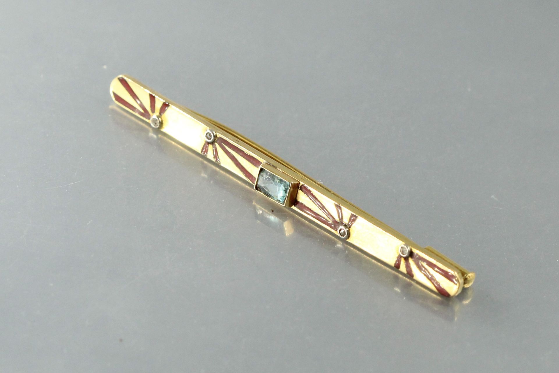 Null 一枚18K（750）黄金胸针，中间有一颗海蓝宝石，四颗钻石镶嵌着红色珐琅。约1930年。

毛重：5.40克。