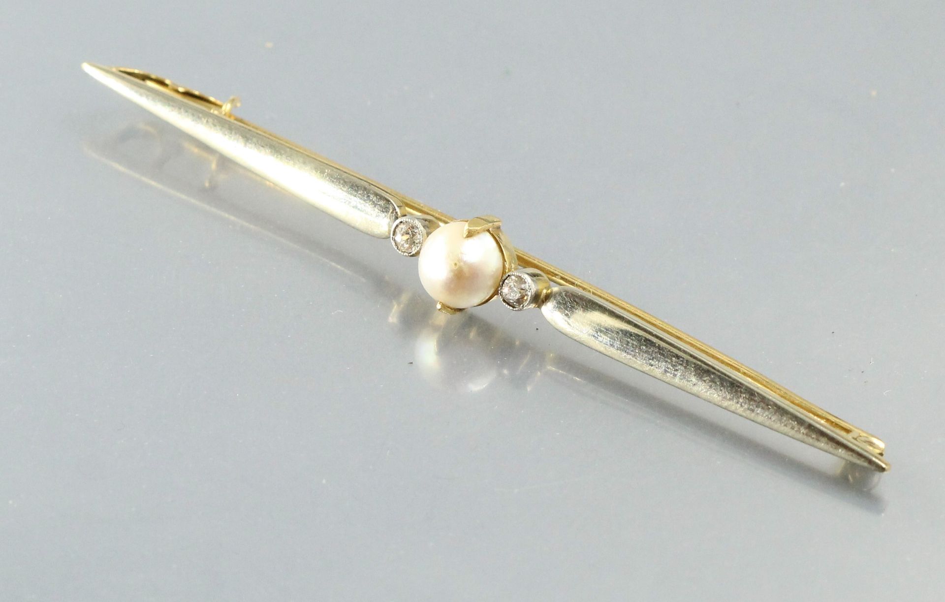 Null 18K（750）白金和黄金胸针，中央有一颗珍珠，两边有一颗钻石。

标有一个鹰头。

长度：7.5厘米。毛重：6.91克。