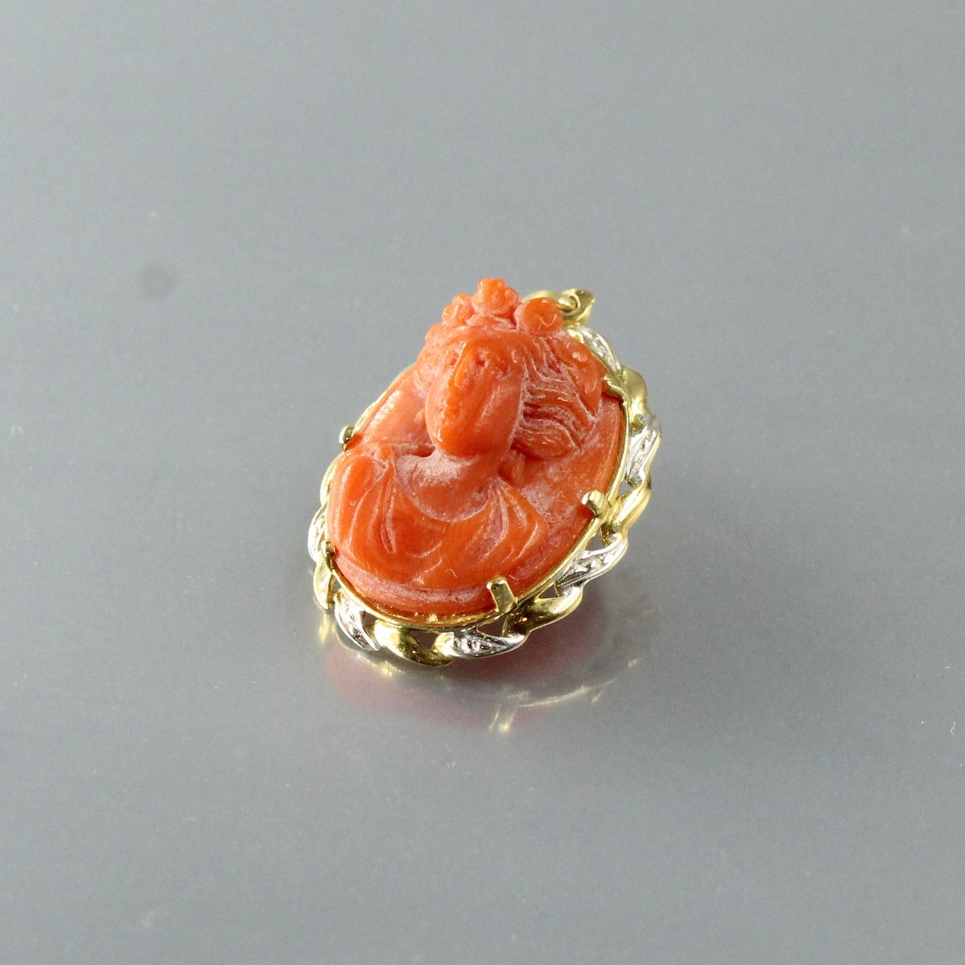 Null An 18k (750) yellow gold coral cameo brooch representing a woman.

Marked w&hellip;
