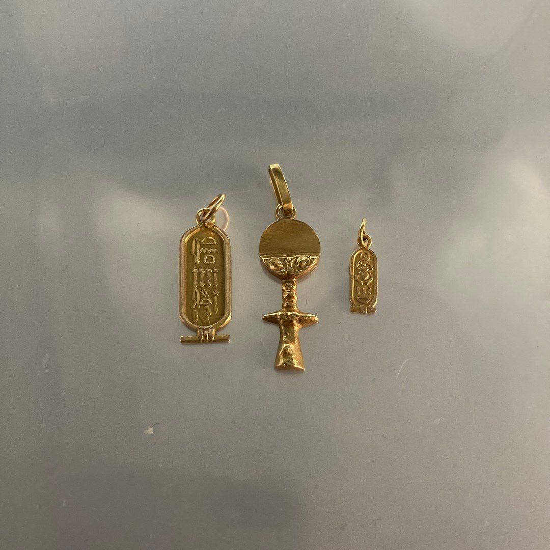 Null Two 18k (750) yellow gold pendants, one with an Egyptian motif and one feat&hellip;