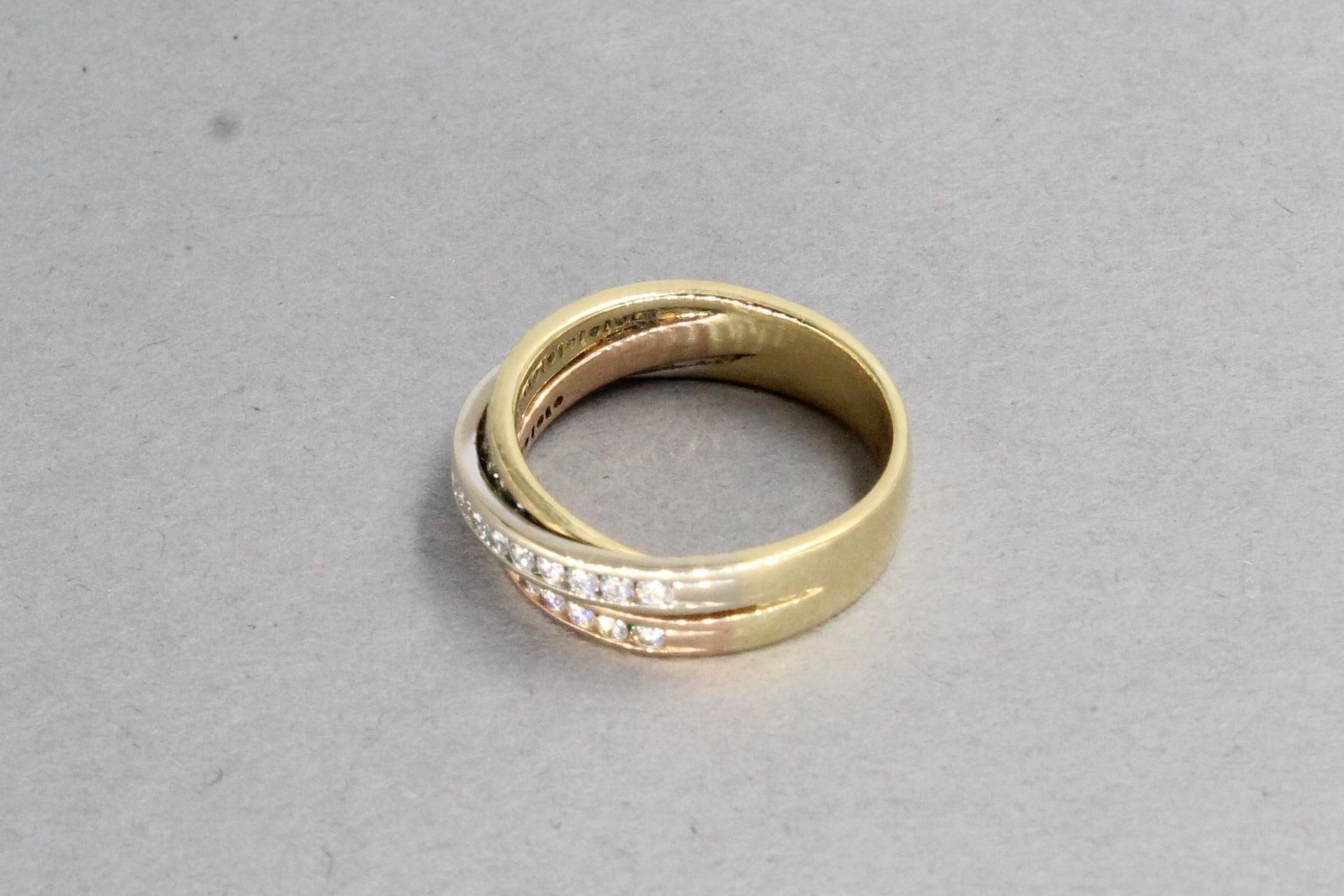 Null 18K(750)黄金和玫瑰金戒指，交叉的缎带上镶嵌着明亮式切割钻石。

标有一个鹰头。

手指大小：53 - 毛重：6.22g。