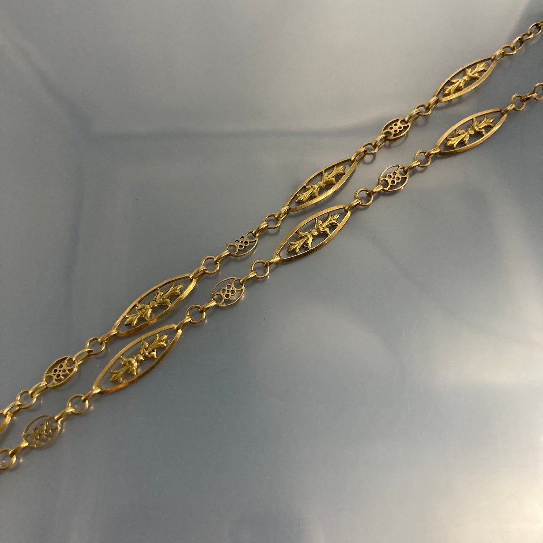 Null 18K (750) gold navette chain with small stylized scrolls.

Weight : 10.3 g.&hellip;