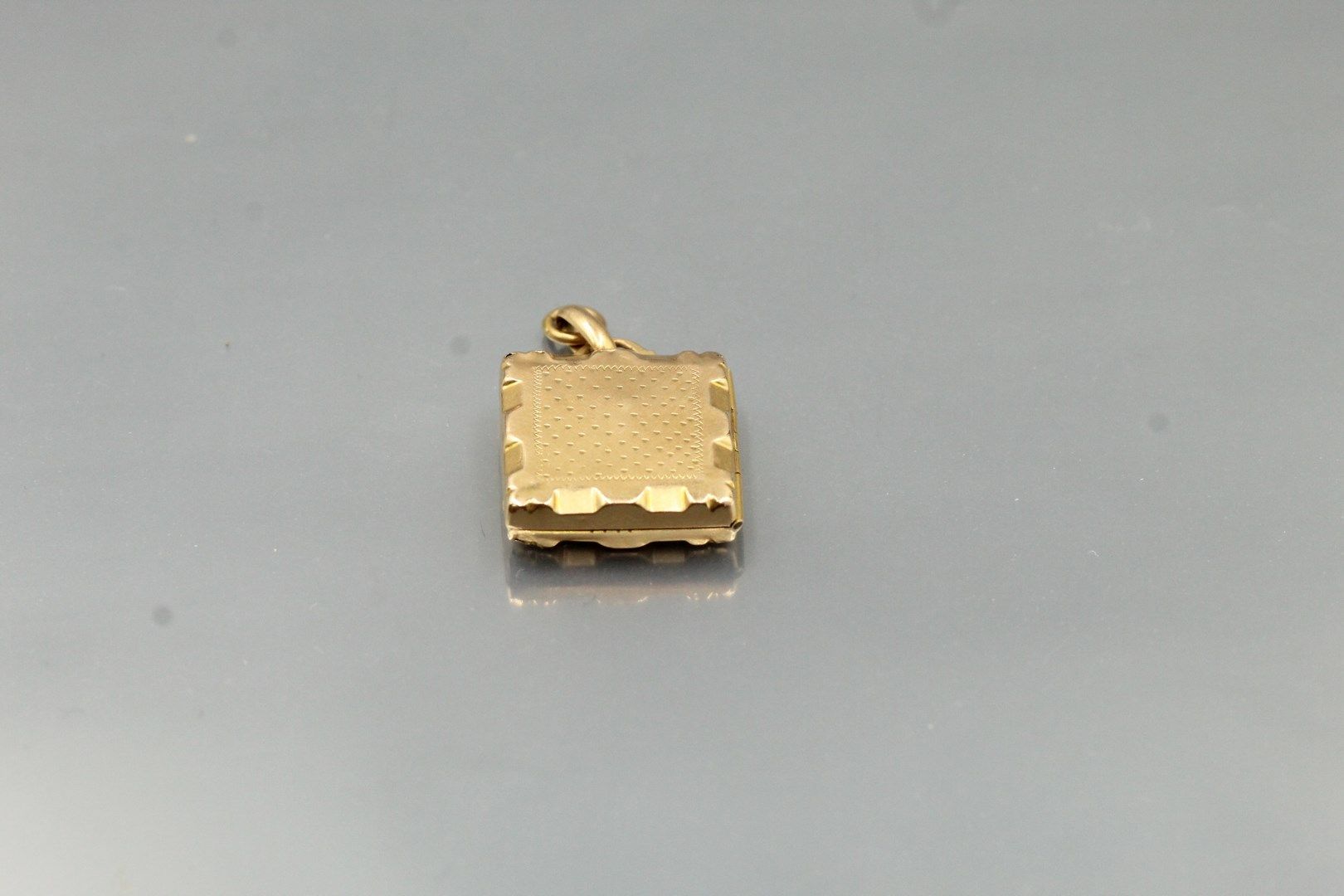 Null 18k (750) yellow gold pendant with chased motif.

Gross weight: 8.14 g.