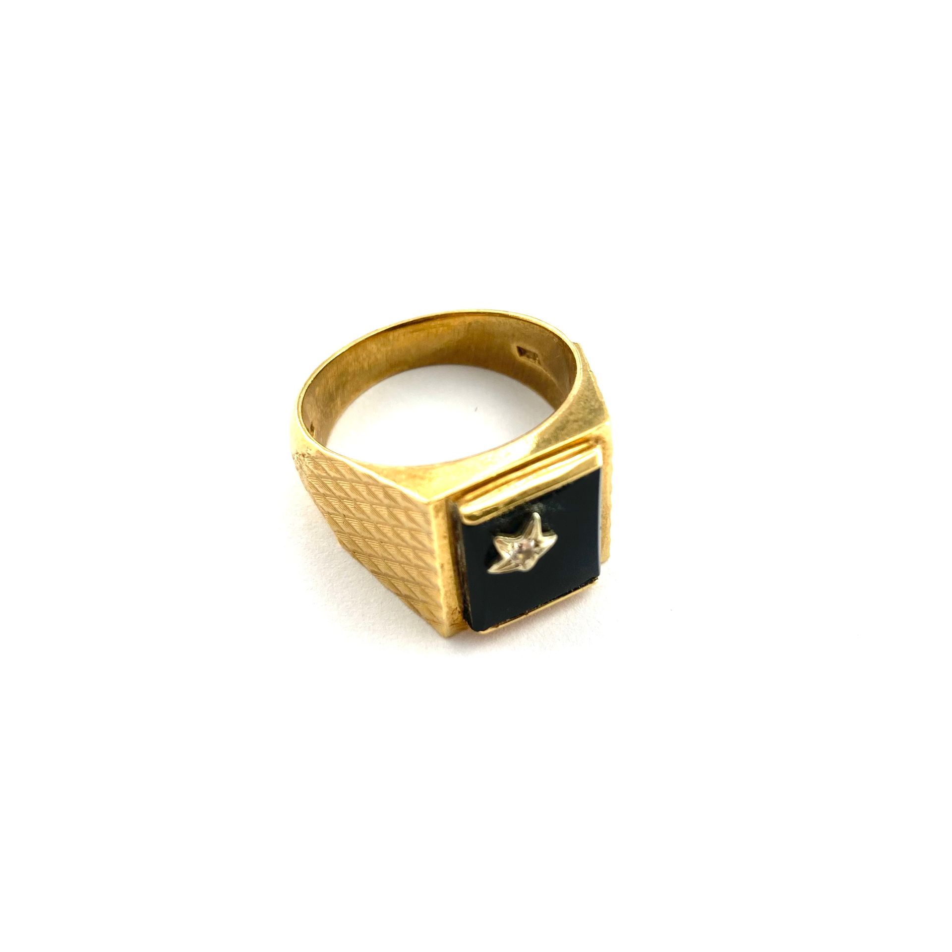 Null 18K(750)黄金戒指，镶有黑玛瑙边框，一颗宝石镶嵌成星形。

手指大小： - 毛重：16.10克。