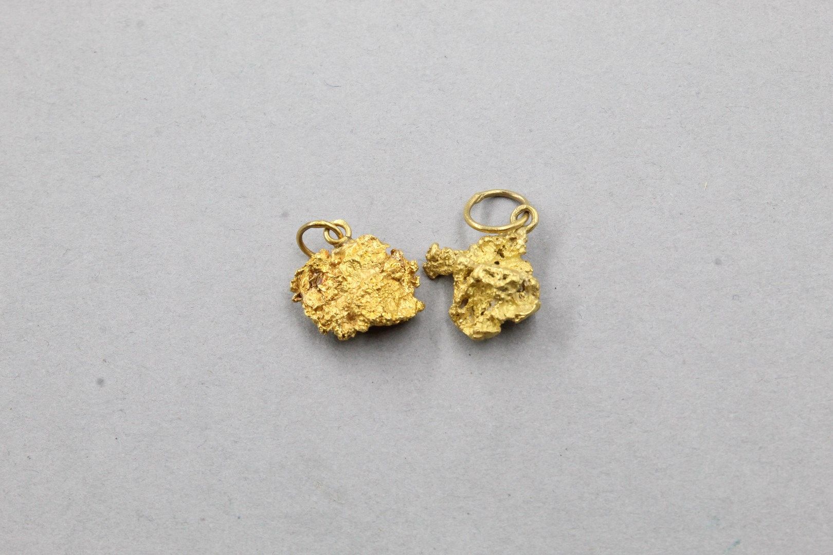 Null Set di due ciondoli di pepita in oro giallo 18k (750). 

Peso: 9,55 g.