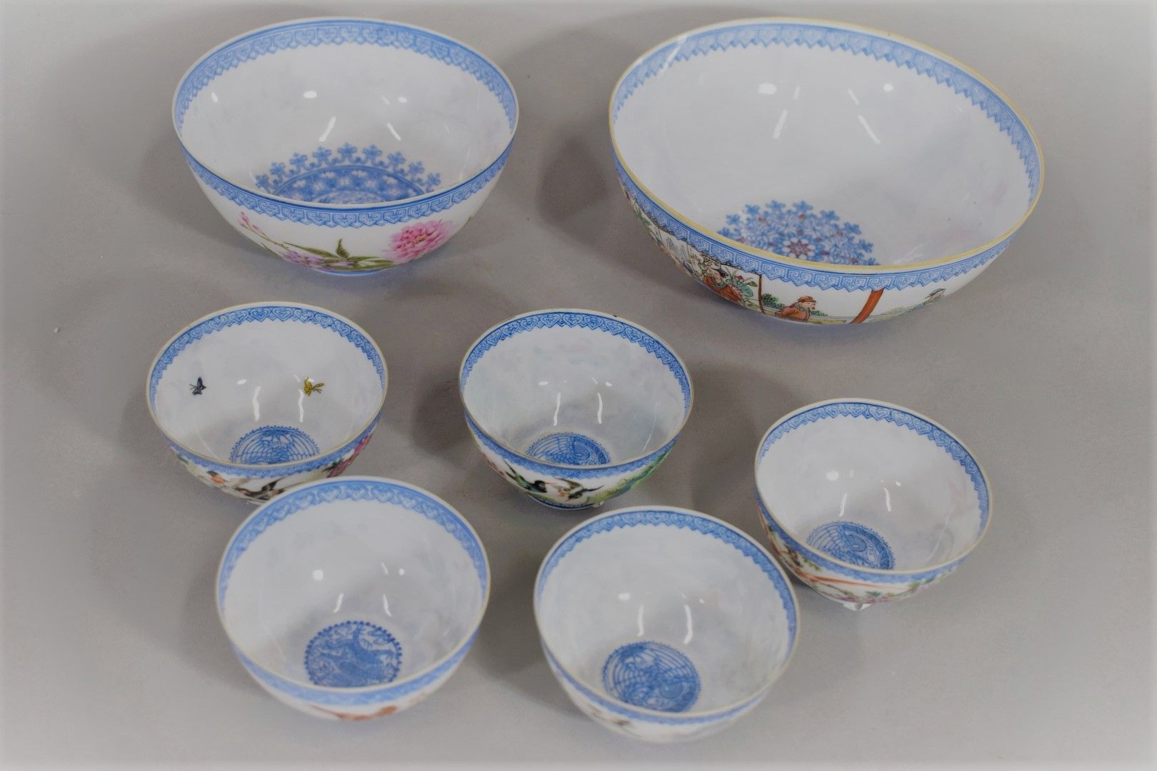 Null 中国，20世纪

一套七只瓷碗，上面有多色珐琅彩装饰的政要和仆人、花和鸟。

底座上的标记。

直径8.3厘米、14厘米和18厘米。