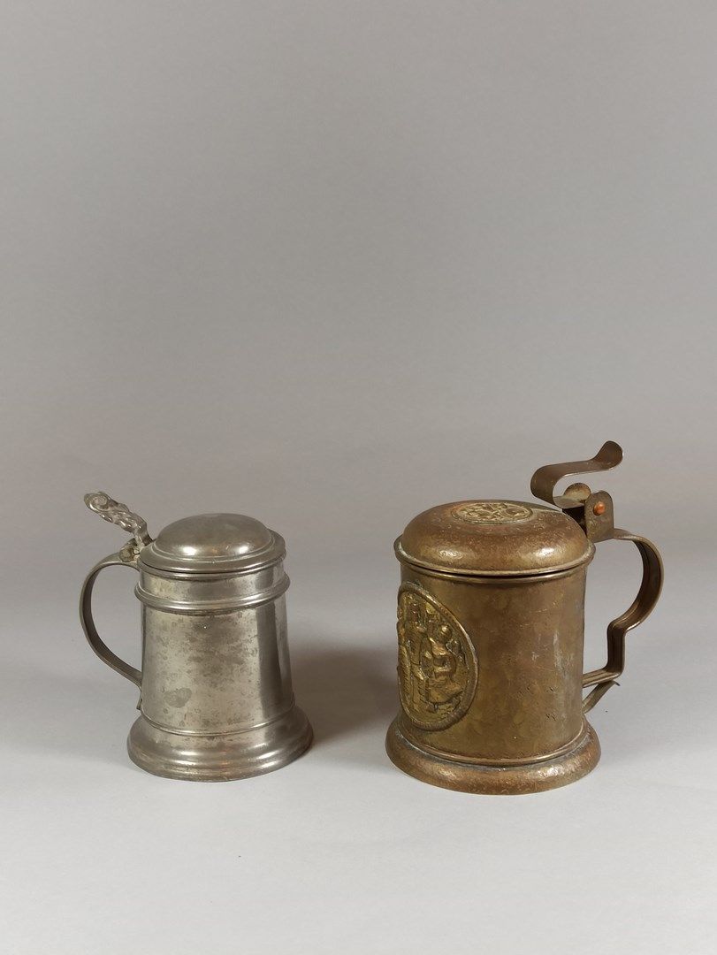 Null 一套两个啤酒杯。

一个是锡制的，另一个是锤制铜制的，壶身和壶盖上的文字是一个奖章。

轻微的氧化，开裂。