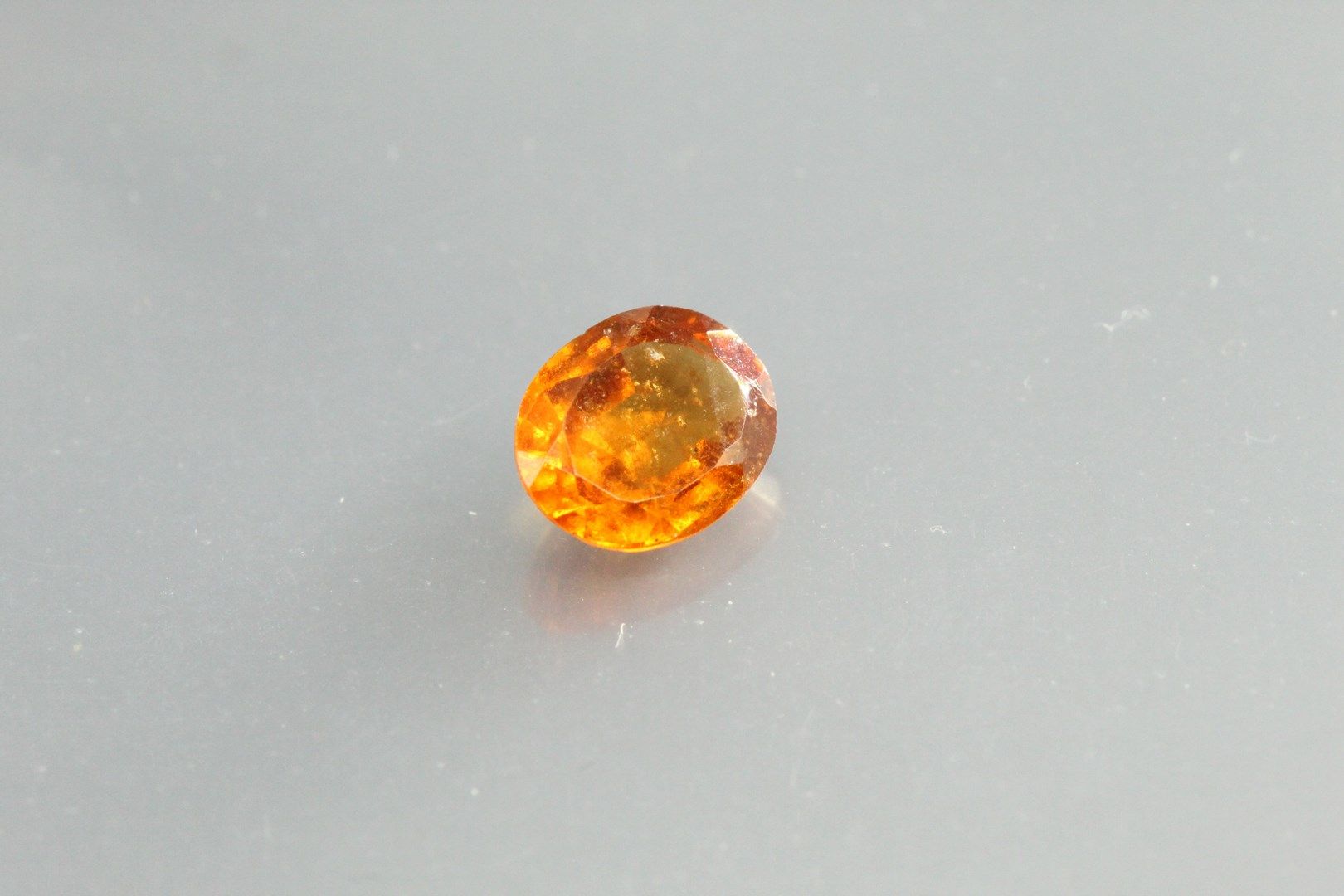 Null 橙色石榴石 - 纸上的椭圆形重晶石。

重量：1,70克拉。