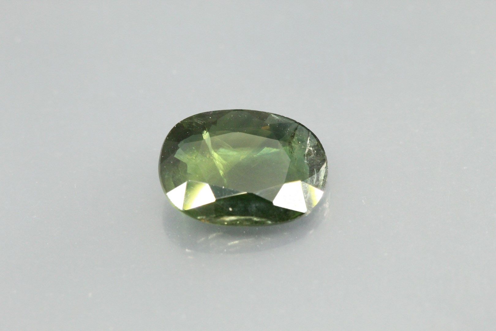 Null Ovaler grüner Saphir auf Papier. 

Gewicht: 3, 05 ct. 

Ablösungsplan.