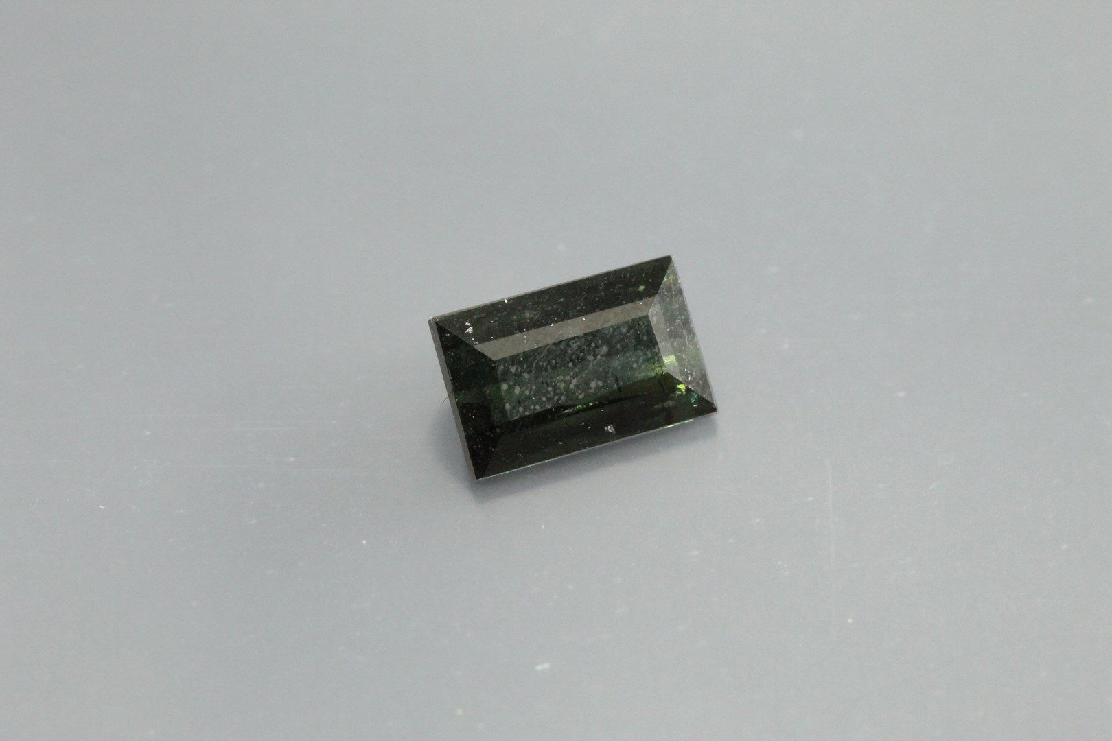 Null Green tourmaline baguette on paper.

Weight : 1, 05 cts.
