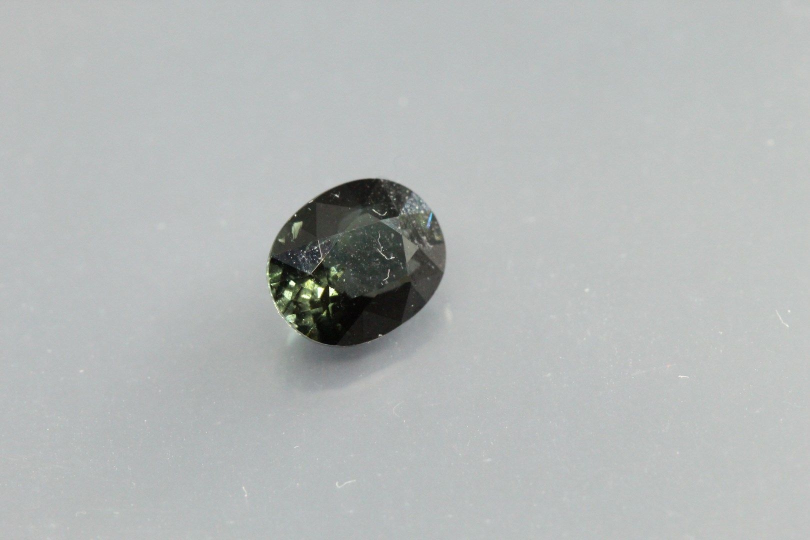 Null Blue tourmaline oval on paper.

Weight : 1, 28 cts. 

Plan of detachment.