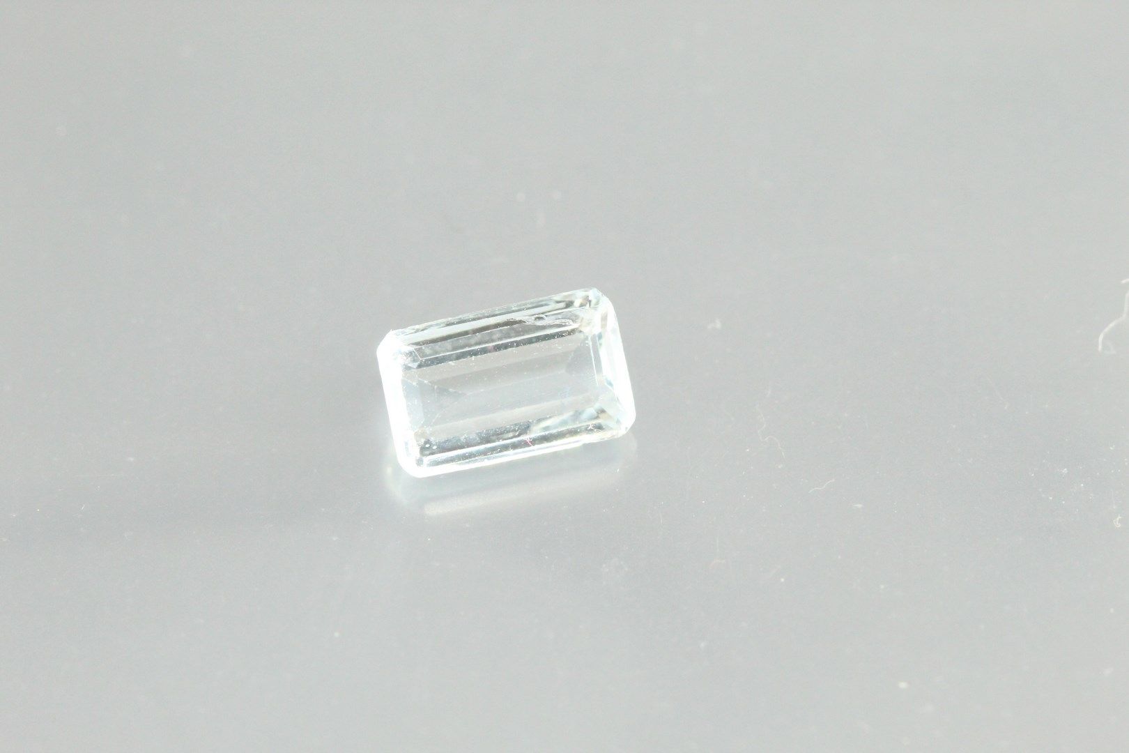 Null Aquamarine baguette on paper.

Weight : 1, 22 cts.

Scratches.