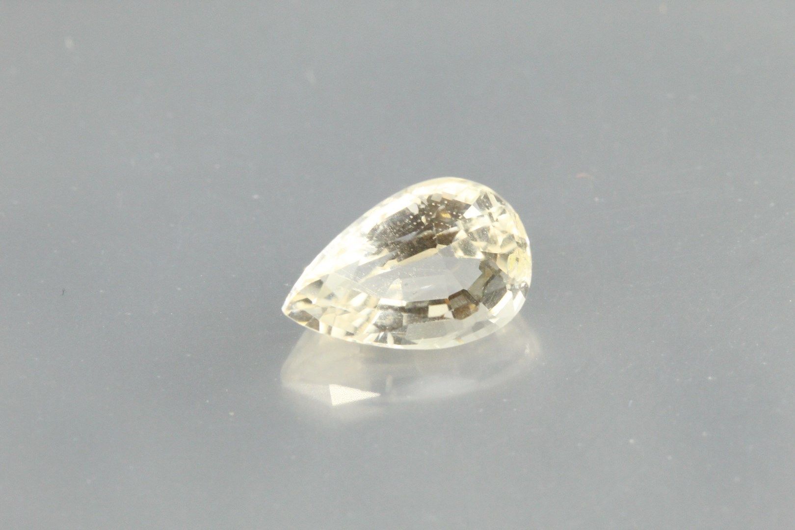 Null Scapolite yellow pear on paper.

Weight: 2, 10 cts. 

Scratches and plane o&hellip;