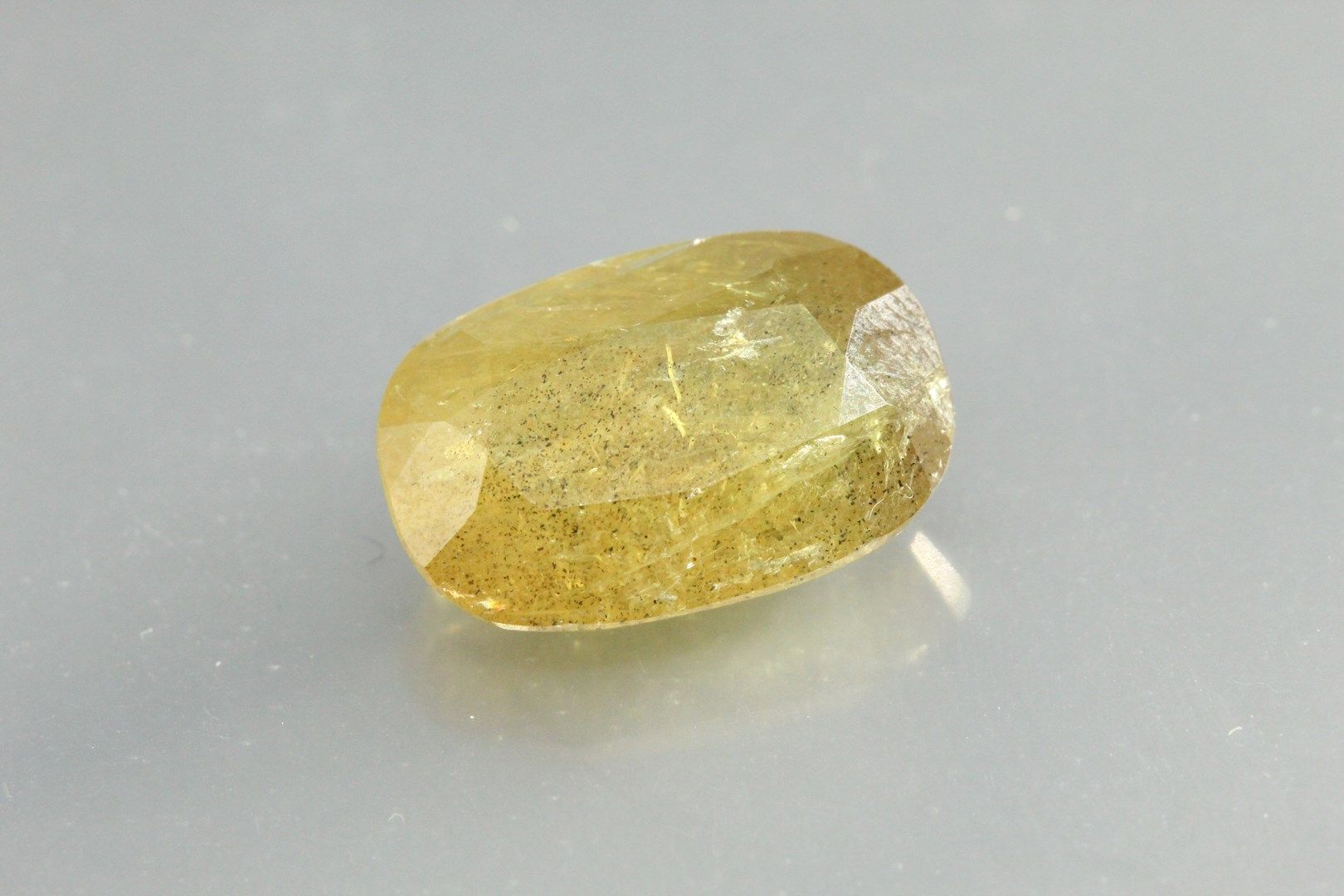 Null Yellow sapphire cushion on paper.

Weight : 12, 28 cts.

Scratches.