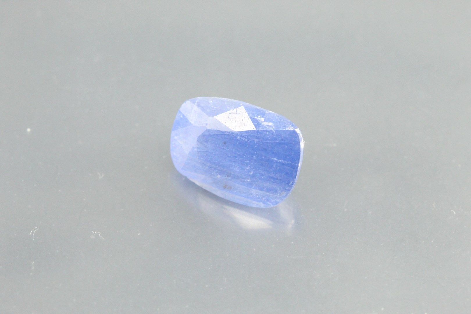 Null Kissenförmiger blauer Saphir auf Papier.

Begleitet von einem AIG-Zertifika&hellip;