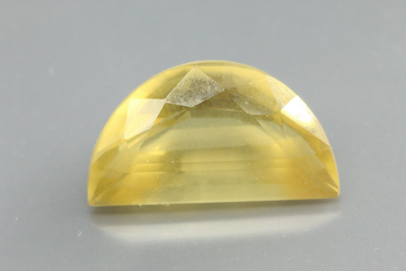 Null Yellow quartz - Citrine faceted (half-moon) on paper. 

Weight : 9, 96 cts.