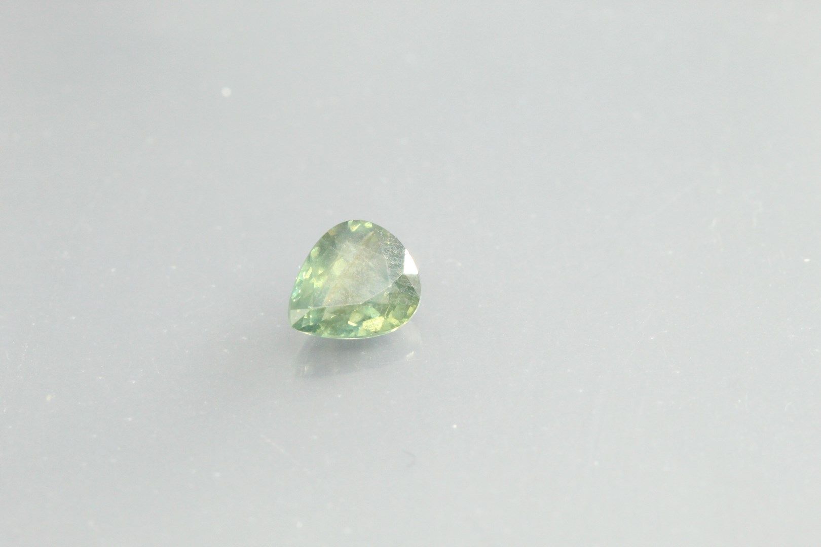 Null Saphir vert/bleu poire sur papier.

Poids : 1, 05 cts.