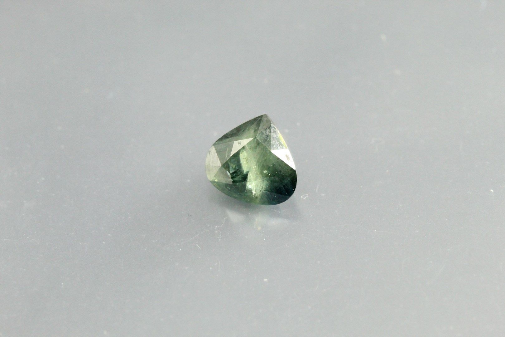 Null Pear green sapphire on paper.

Heated. 

Australia 

Weight : 1, 82 cts.