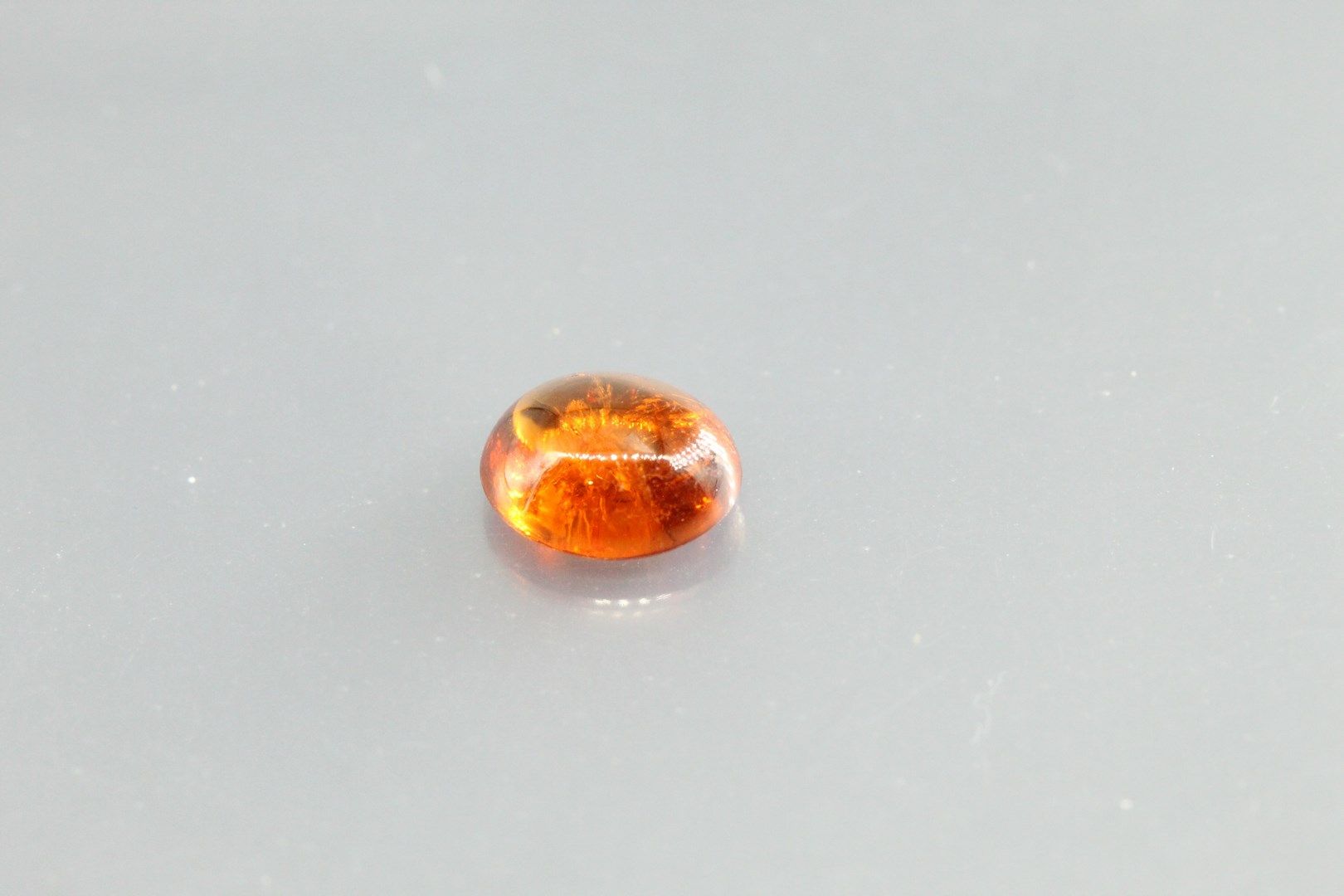 Null Orange garnet cabochon on paper.

Weight : 1, 87 cts.