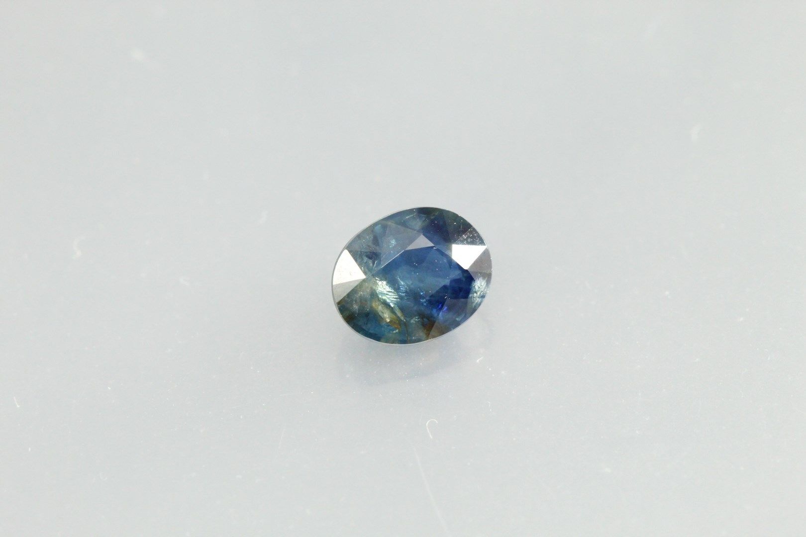Null Blue/green oval sapphire on paper.

Weight : 1, 30 cts.