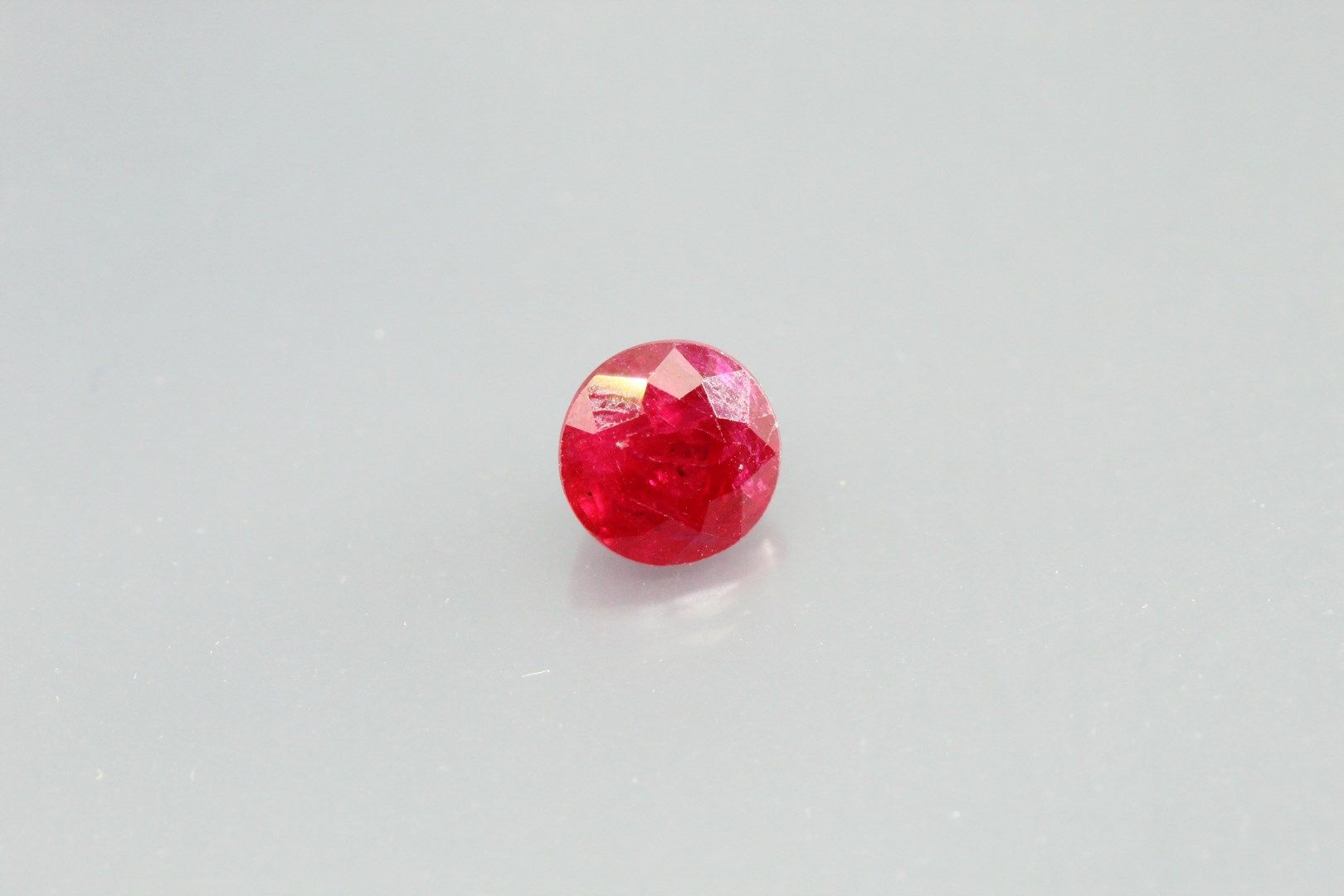 Null 圆形红宝石在纸上。

重量：1.09克拉。

纹理和剥落的平面。