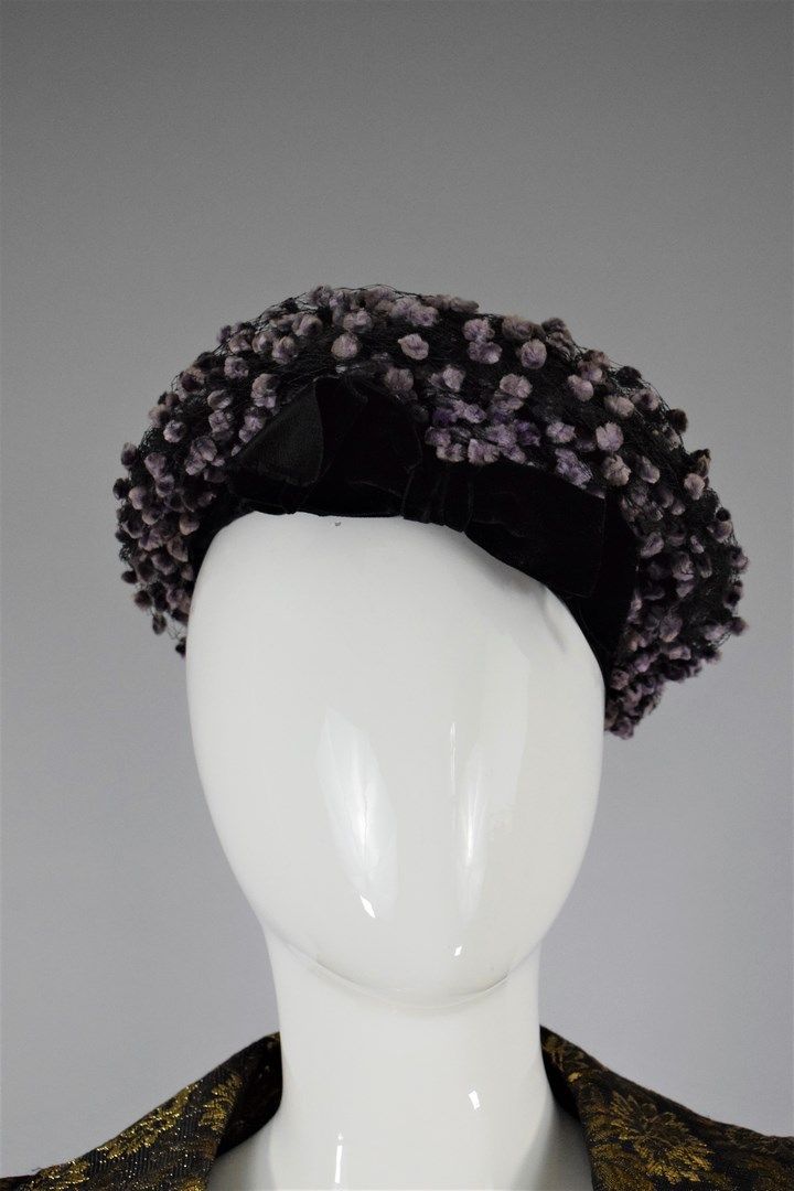 Null BALENCIAGA 

约1960年



贝雷帽式的帽子上装饰着一个黑色的蝴蝶结和黑色的薄纱，上面装饰着紫色的小绒球。 

磨损，轻微事故。 

&hellip;