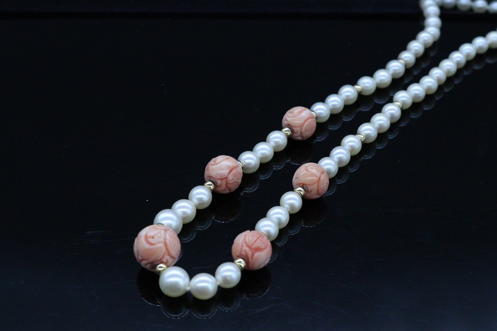 Null 养殖珍珠项链，装饰有雕刻的珊瑚球和黄金卡套，18K（750）金扣。 

长度：62.5厘米左右。- 总重量 : 46,41 克
