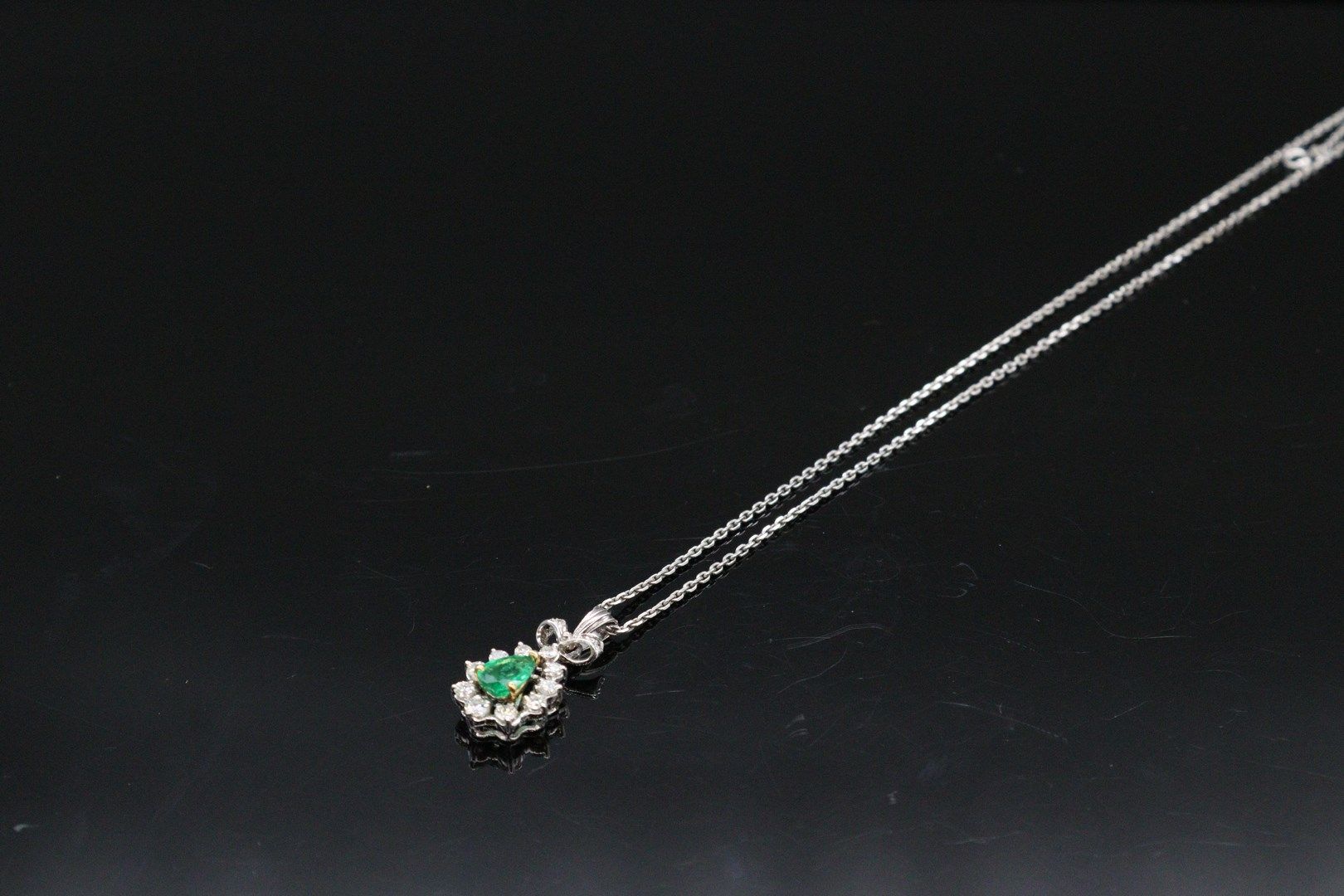 Null 18K(750)白金吊坠和链子，托着一颗镶嵌钻石的梨形切割祖母绿。

毛重：5.81克。