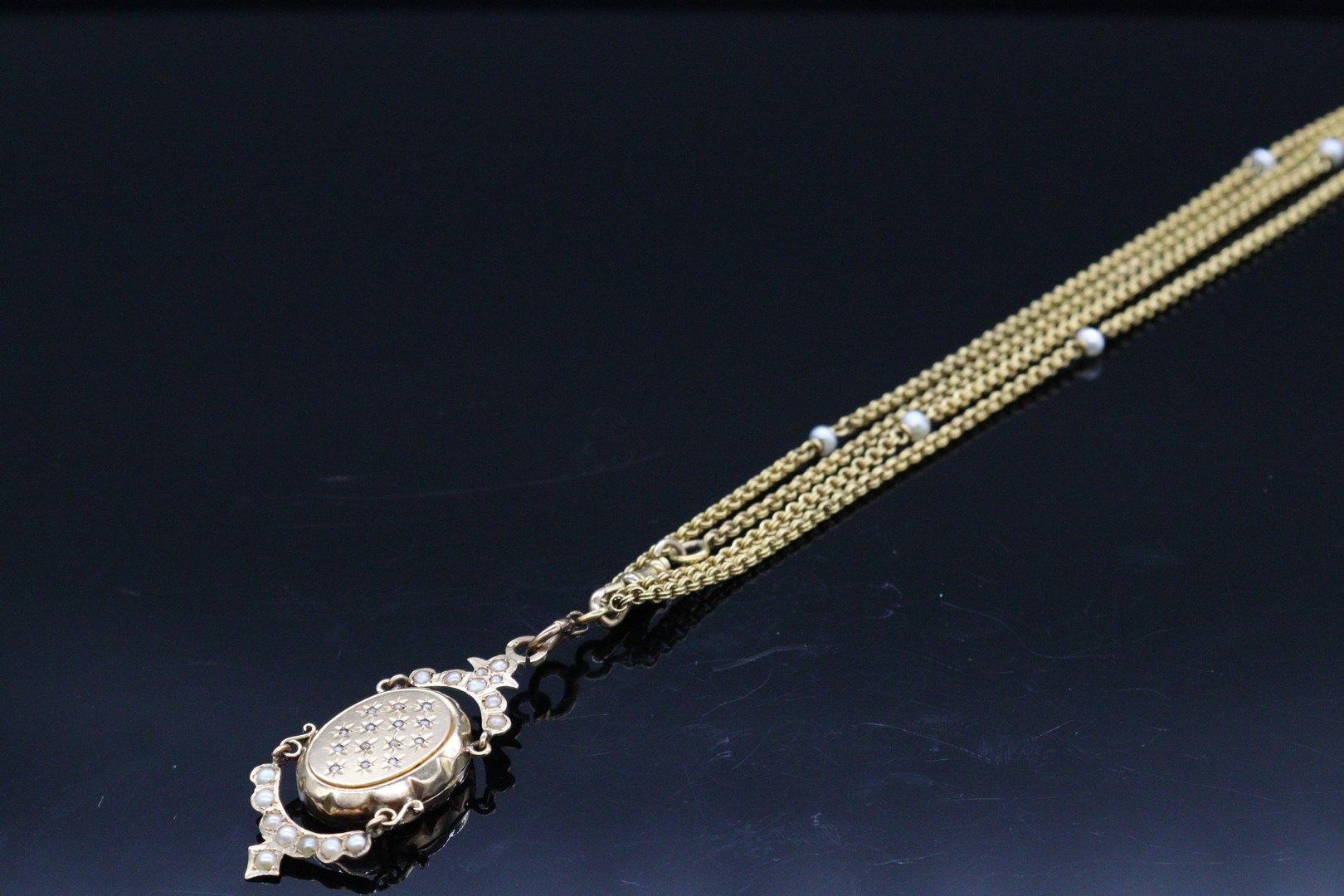 Null 18K（750）黄金吊坠和项链。项链由forçat链接制成，并穿插有珍珠。 吊坠上有半花和珍珠的装饰。 

毛重：39.52克。