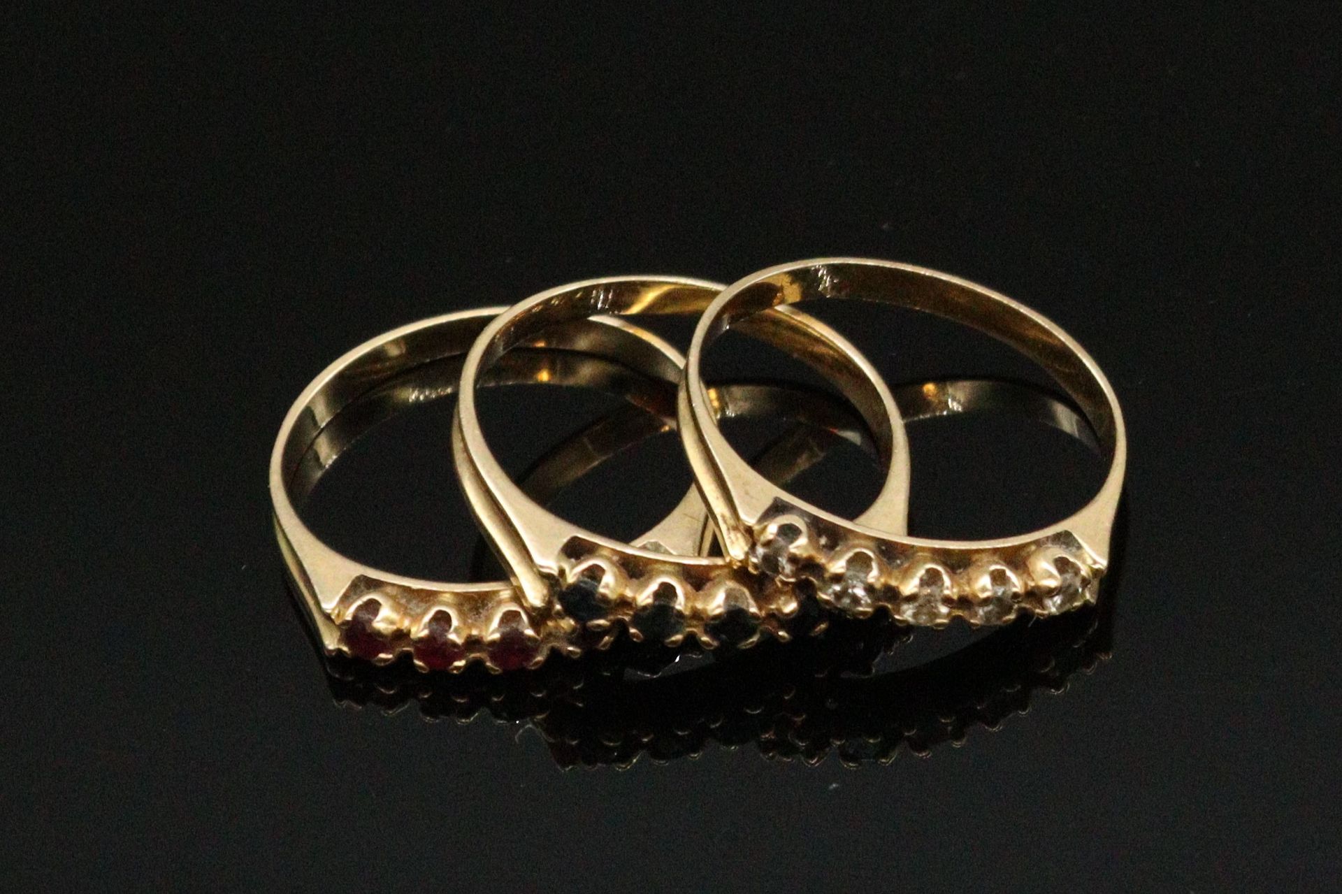 Null 一套三枚18K（750）黄金戒指，镶嵌红宝石、蓝宝石和钻石。 

手指尺寸：55 - 毛重：5.75克。