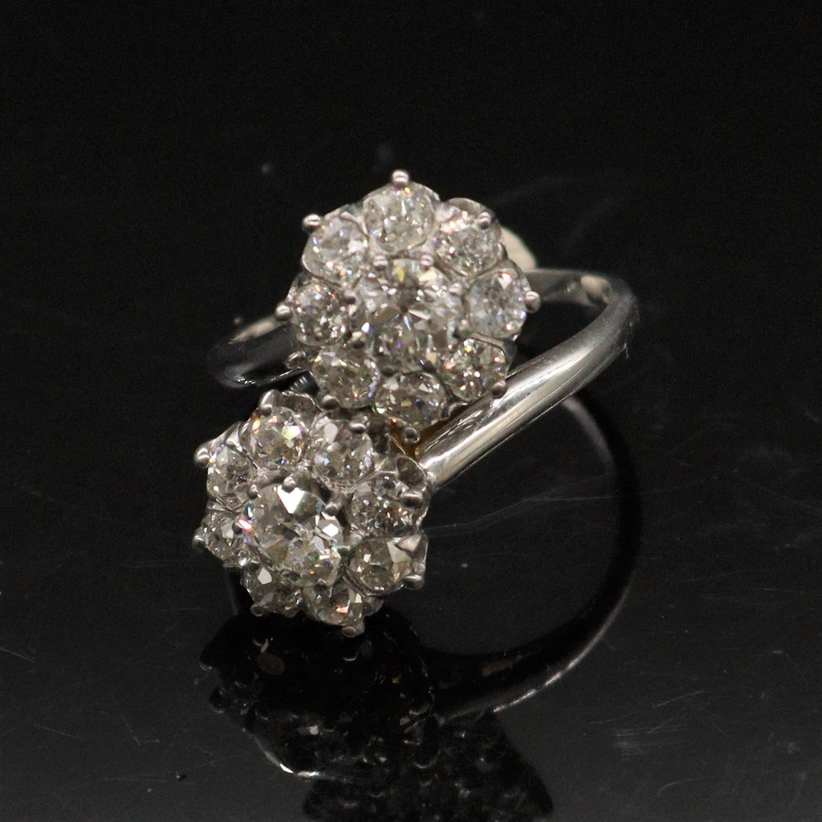 Null 18K(750)白金戒指，上面镶嵌着两朵风格迥异的花朵，并镶有老式切割钻石。

手指尺寸：55/56。- 毛重：6.4克

(筹码)