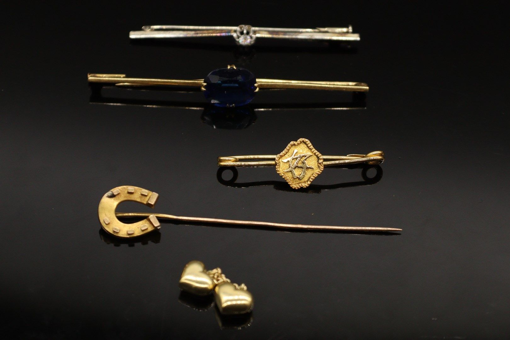 Null Lot of four brooches including: 

- an 18k (750) yellow gold horseshoe-topp&hellip;